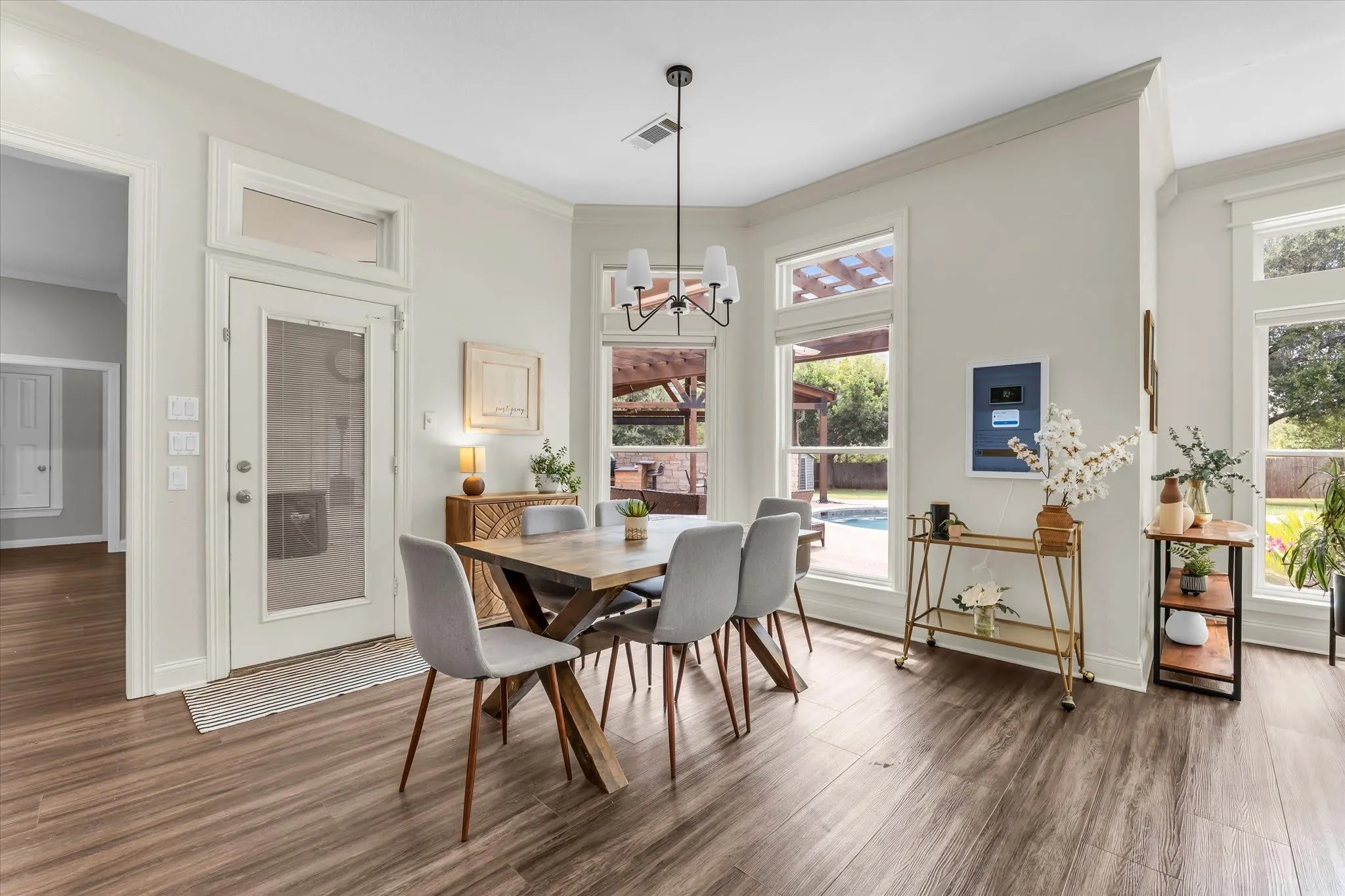 Wood-finish flooring, abundant natural light, recessed lighting, and a contemporary chandelier