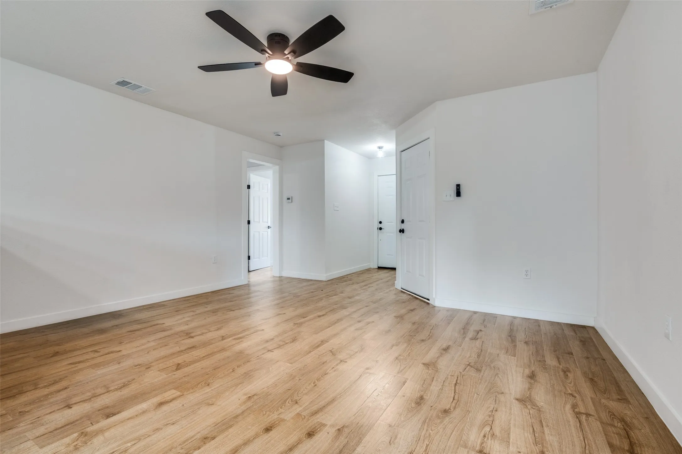 Unfurnished room featuring light wood finished floors and a ceiling fan