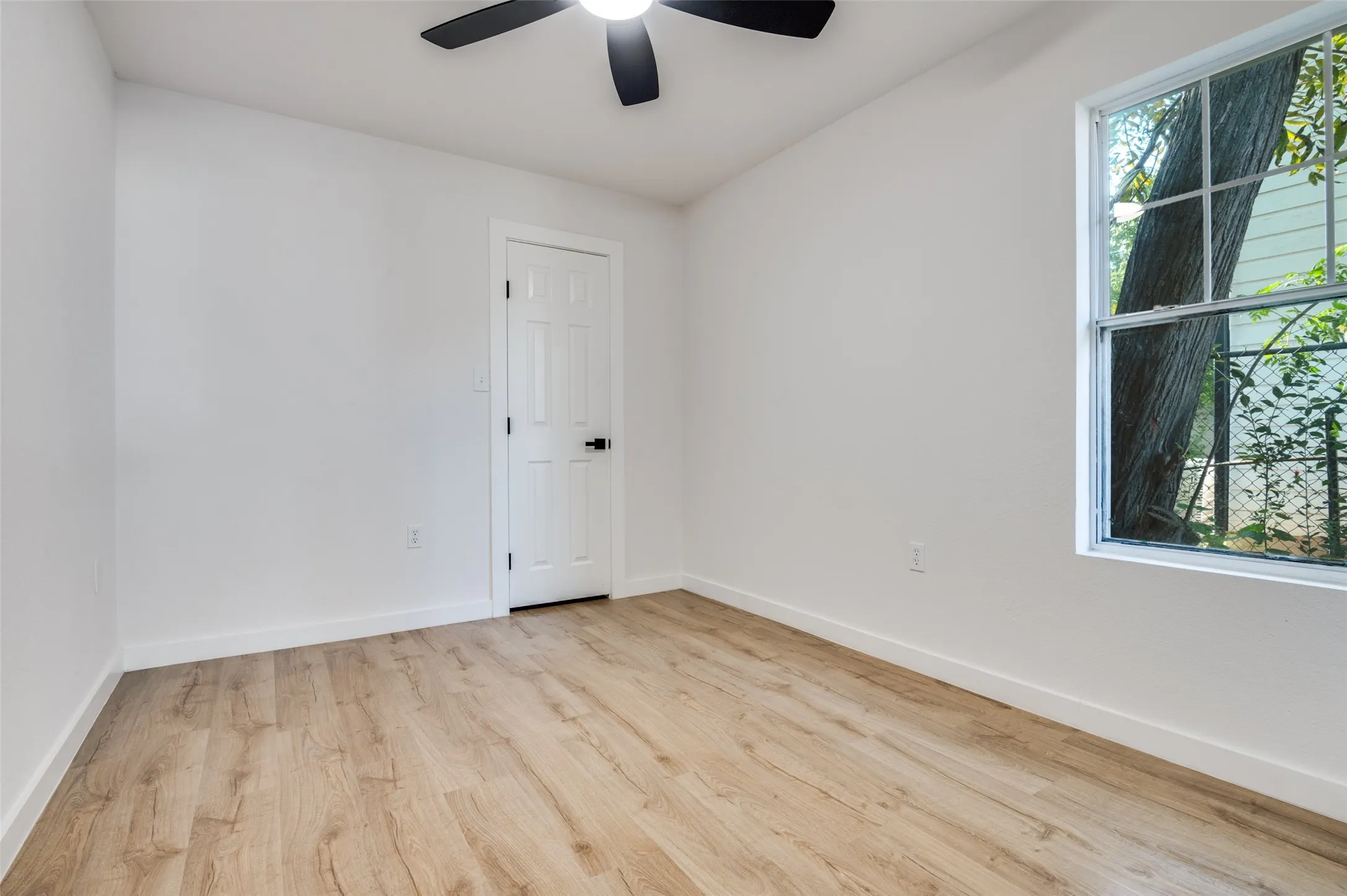 Empty room featuring light wood-style floors and a ceiling fan