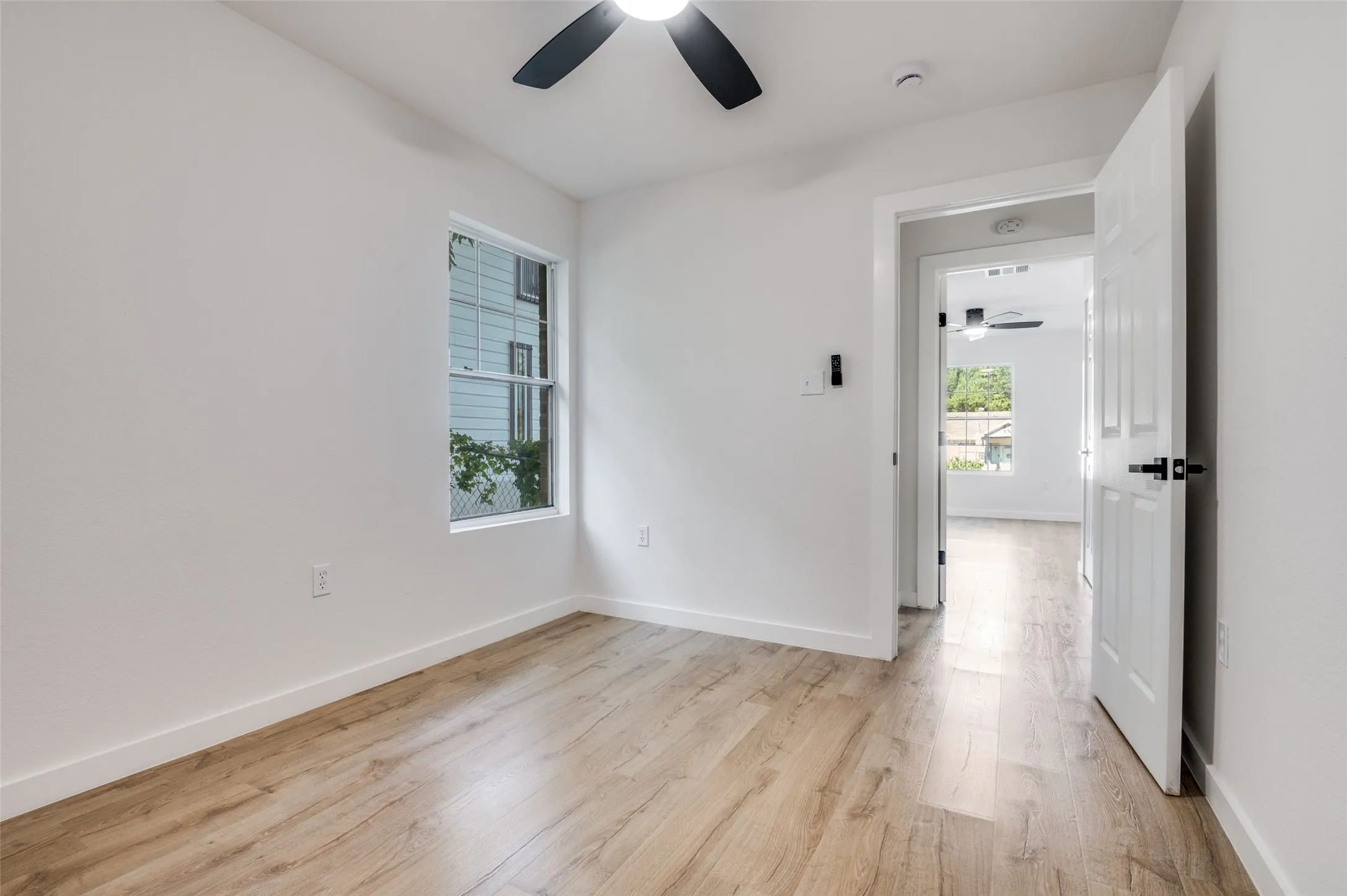 Unfurnished room with a ceiling fan and light wood-type flooring