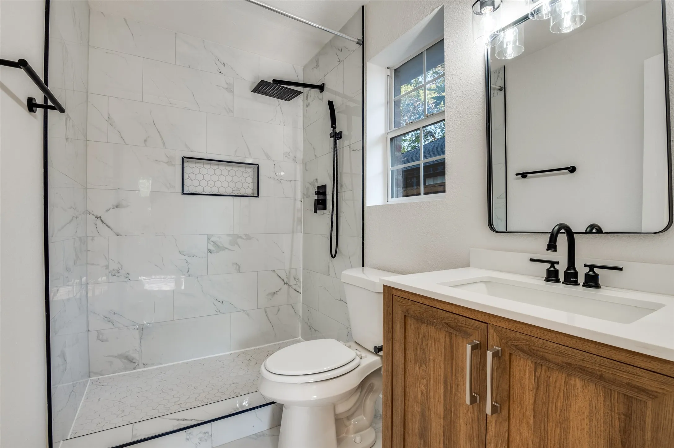 Full bathroom with vanity, a marble finish shower, and marble look tile flooring