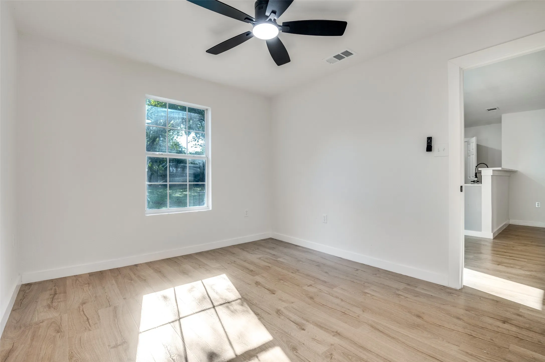 Unfurnished room featuring light wood-style flooring and ceiling fan