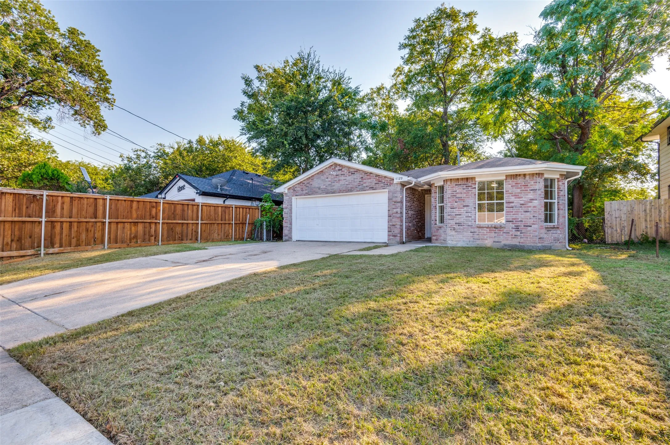 Ranch-style home with concrete driveway, brick siding, and a garage