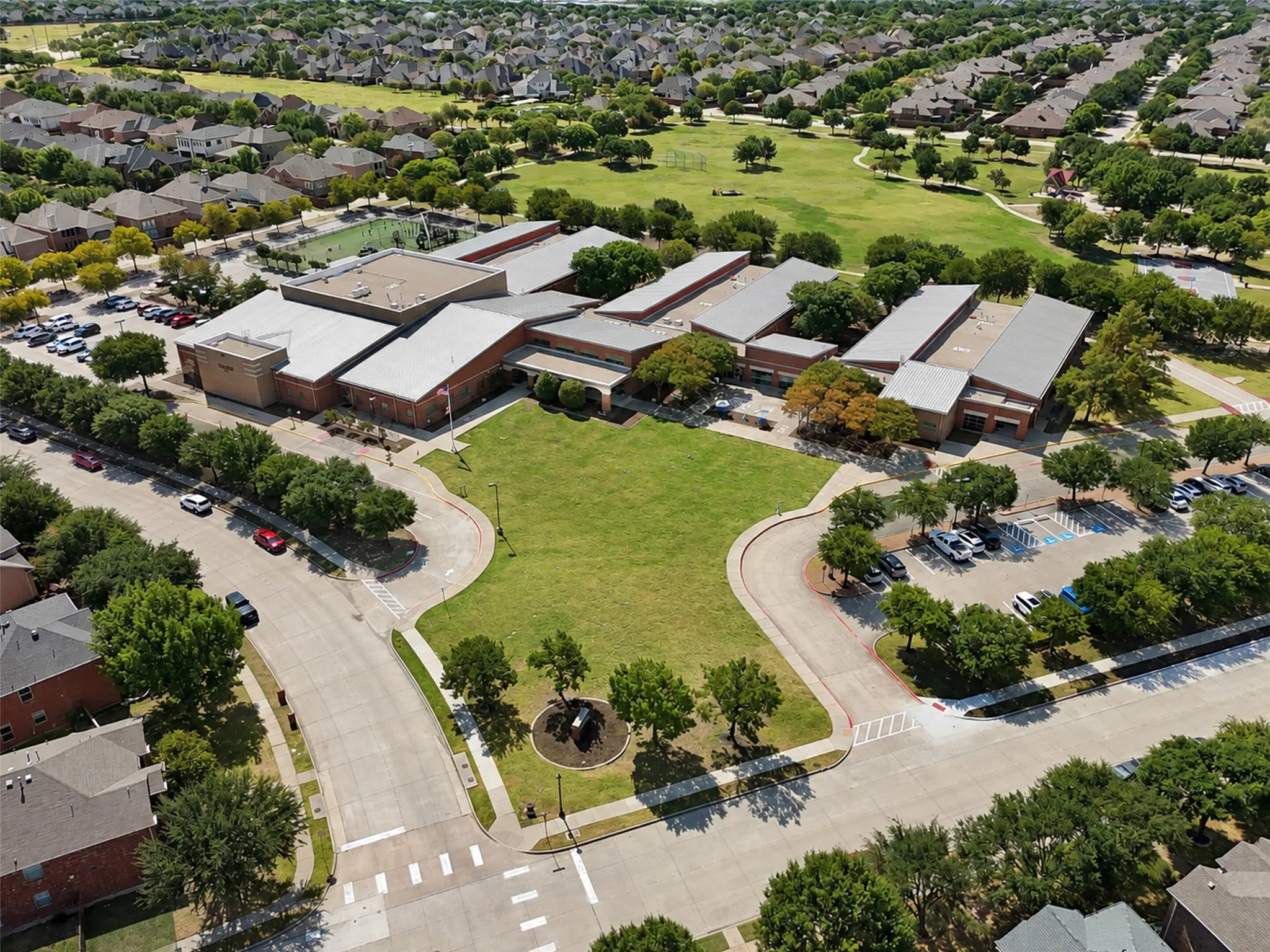 Expansive campus with multiple buildings, large green spaces, and surrounding residential areas