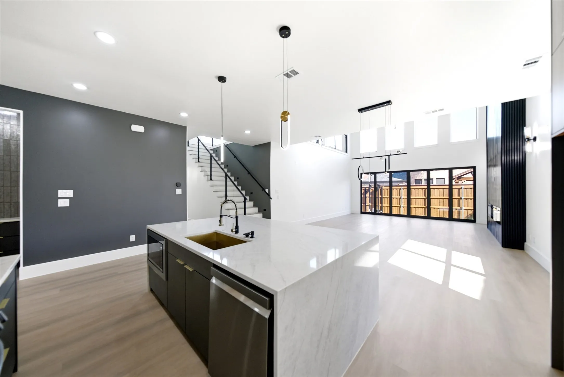 Kitchen island with a gold-finish sink, stainless steel dishwasher, and a light-toned countertop