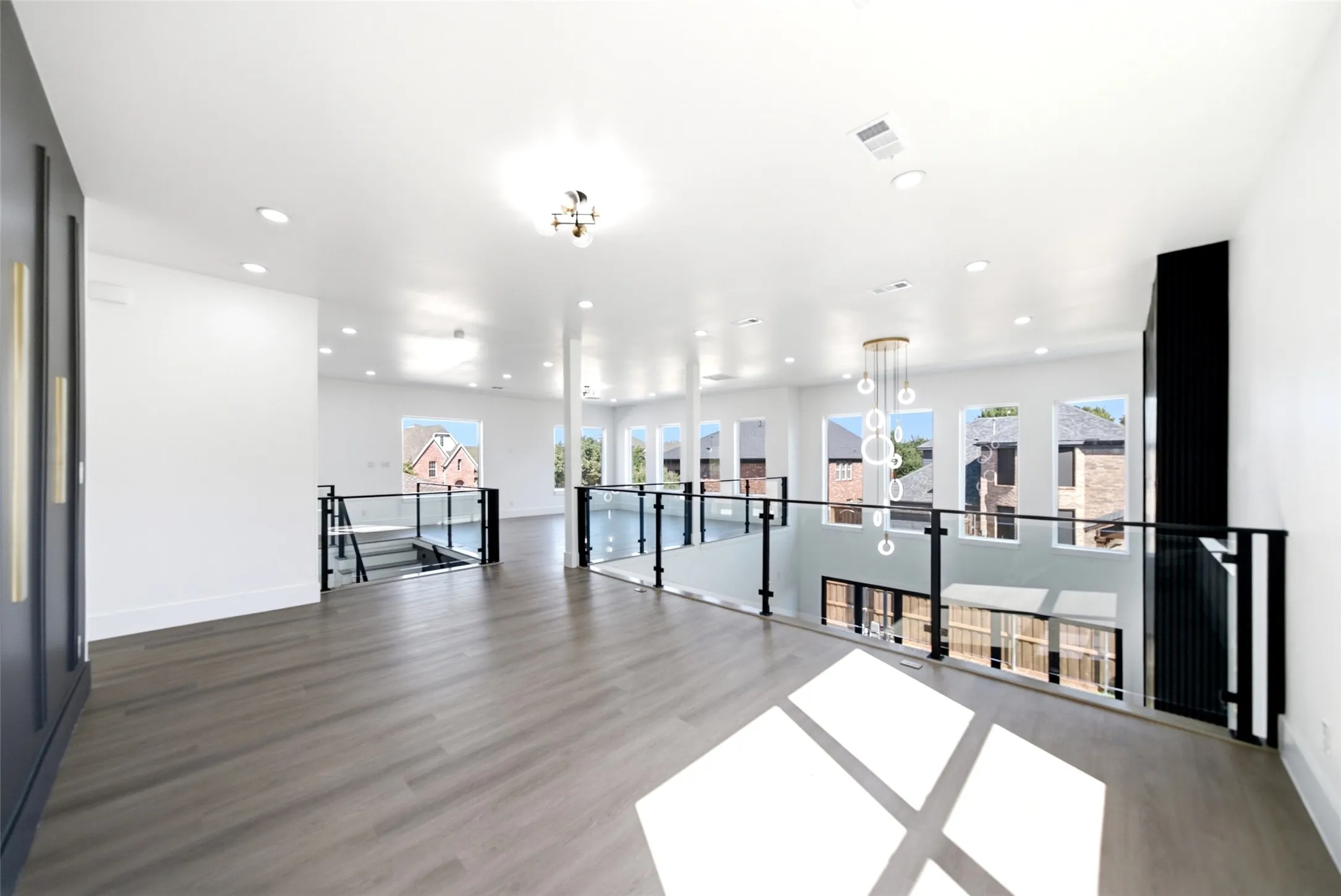 Open-concept space featuring wood-finish flooring, recessed lighting, and a contemporary chandelier