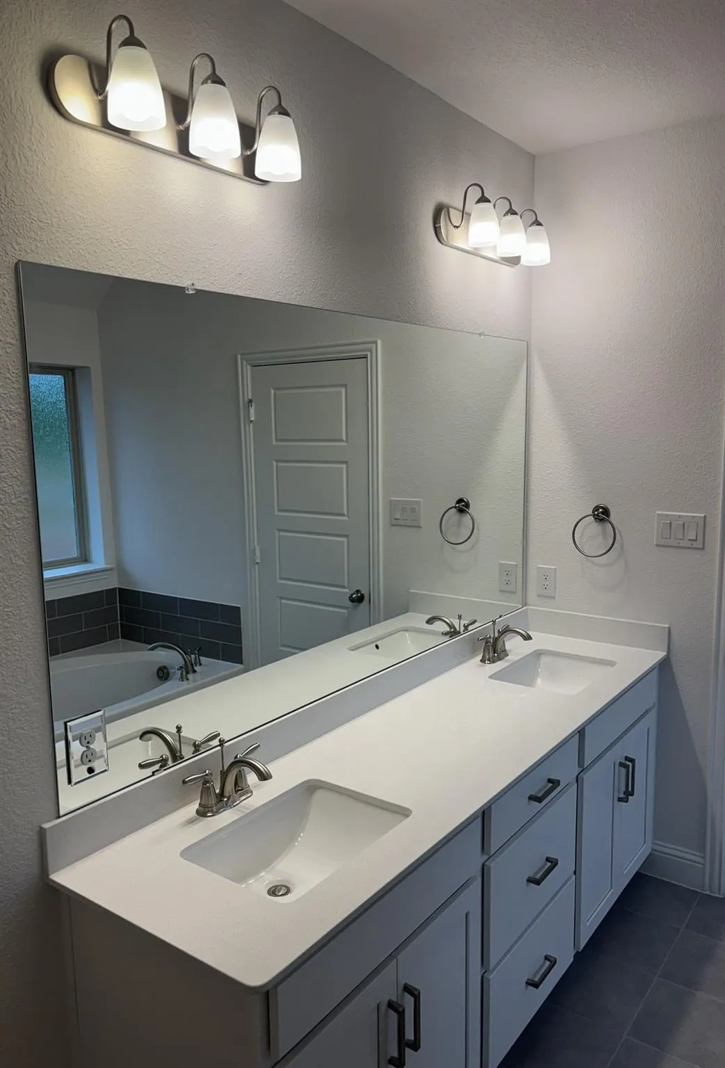 Dual vanity with white countertops, undermount sinks, and brushed nickel faucets