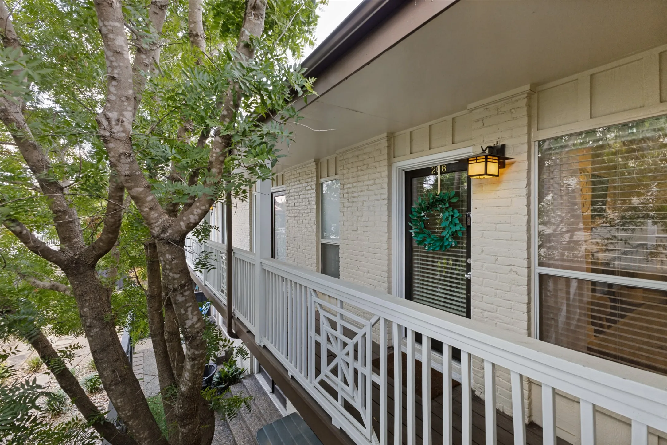 Painted brick exterior with a balcony featuring white railing