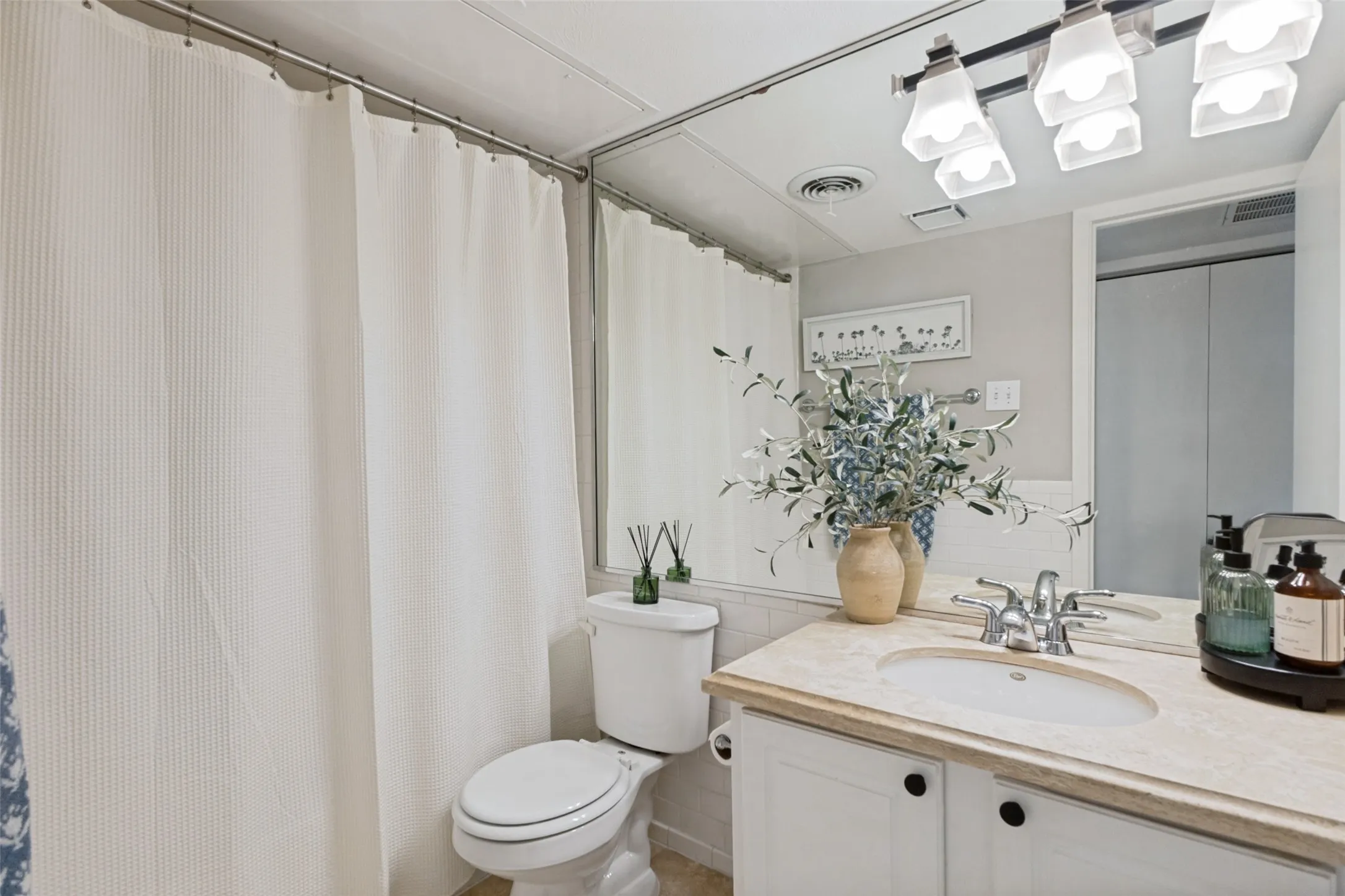 Vanity with an integrated sink, a polished chrome faucet, under-cabinet storage, and a light-toned countertop