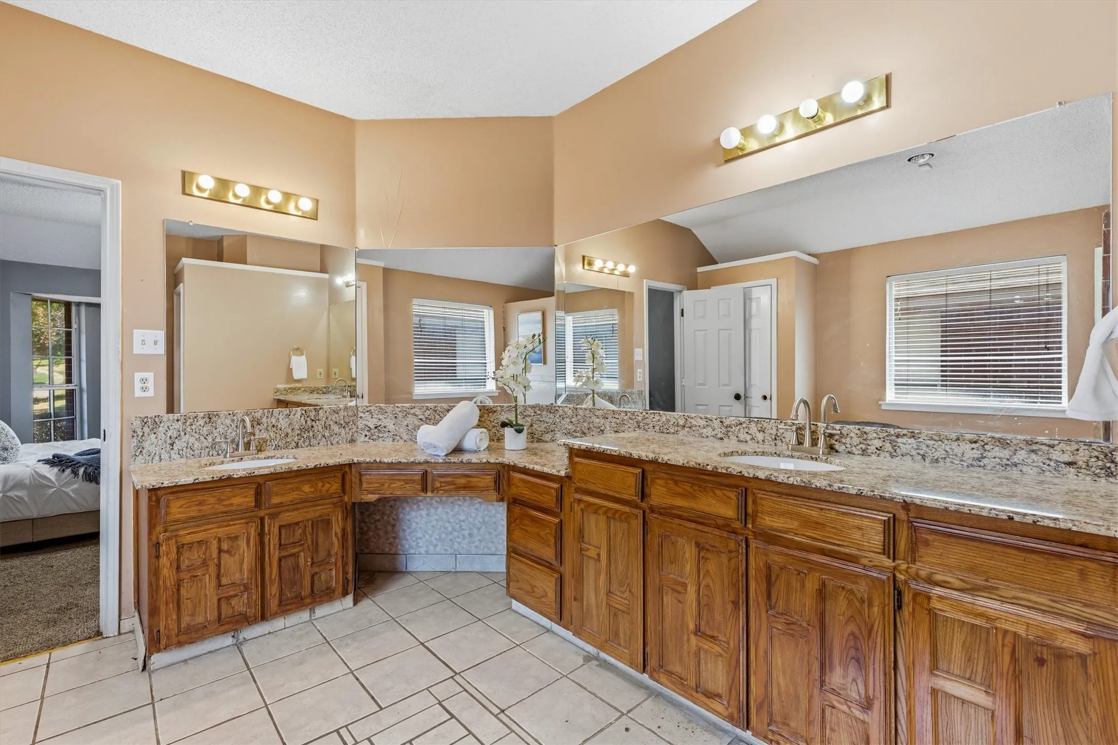 Dual vanity with undermount sinks, granite countertops, and wood-finish cabinetry