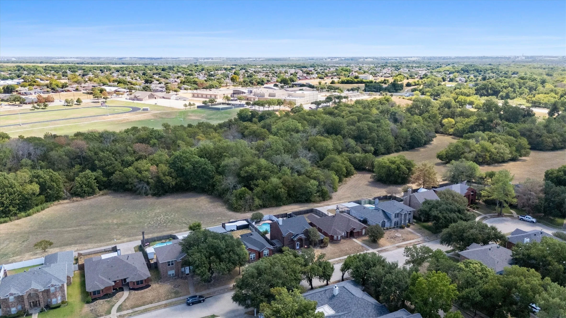 Expansive treed landscape bordering residential properties