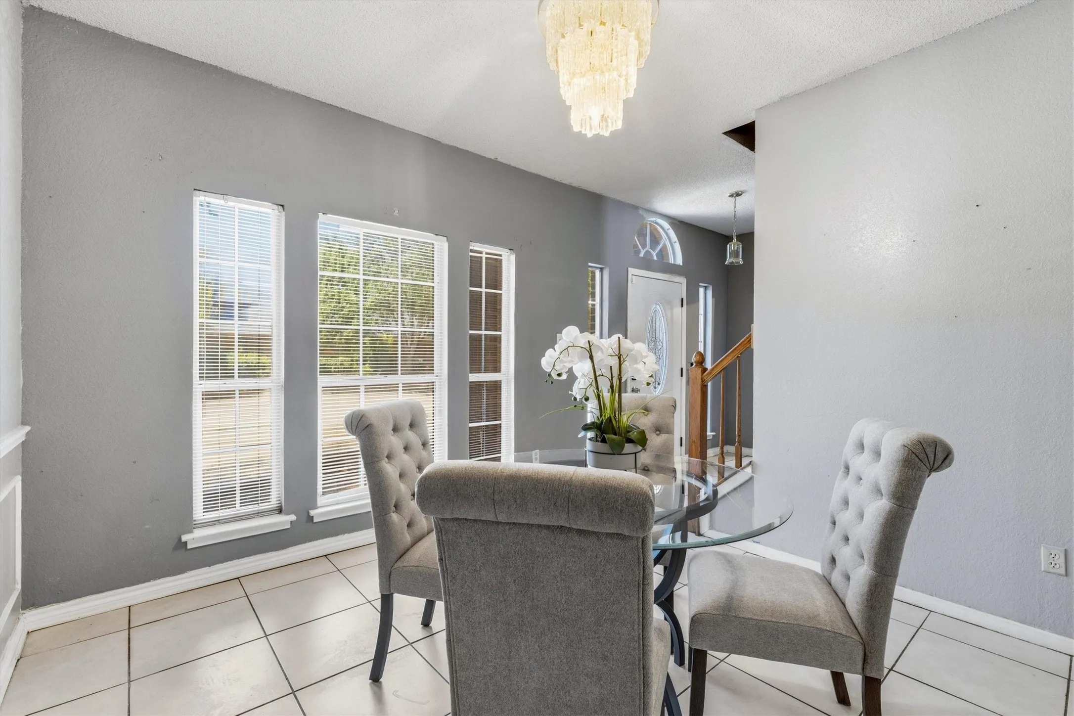 Recessed dining area with tile flooring and multiple windows