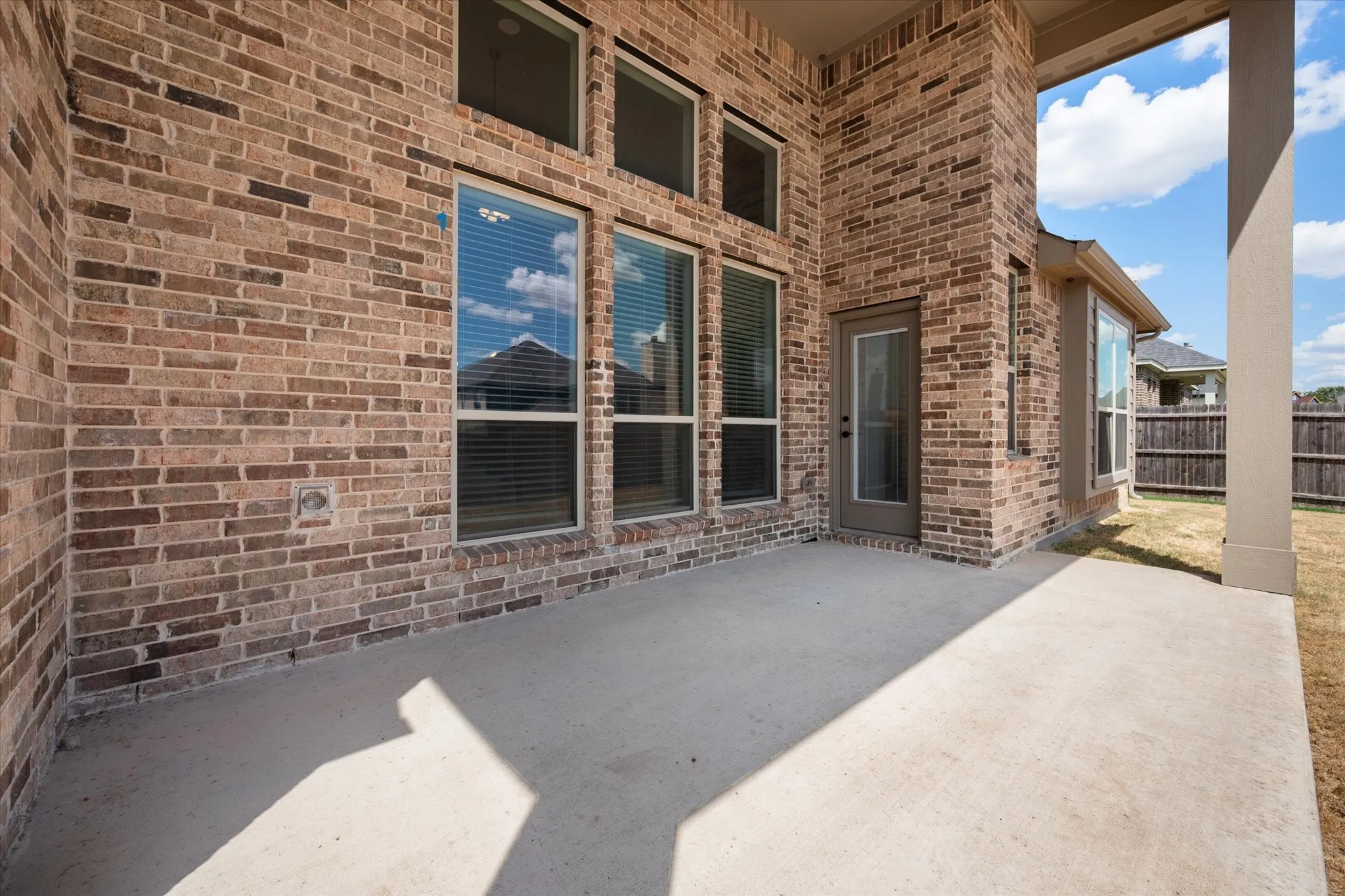 A closer look at the covered patio structure — solid brick, great bones, built to last.