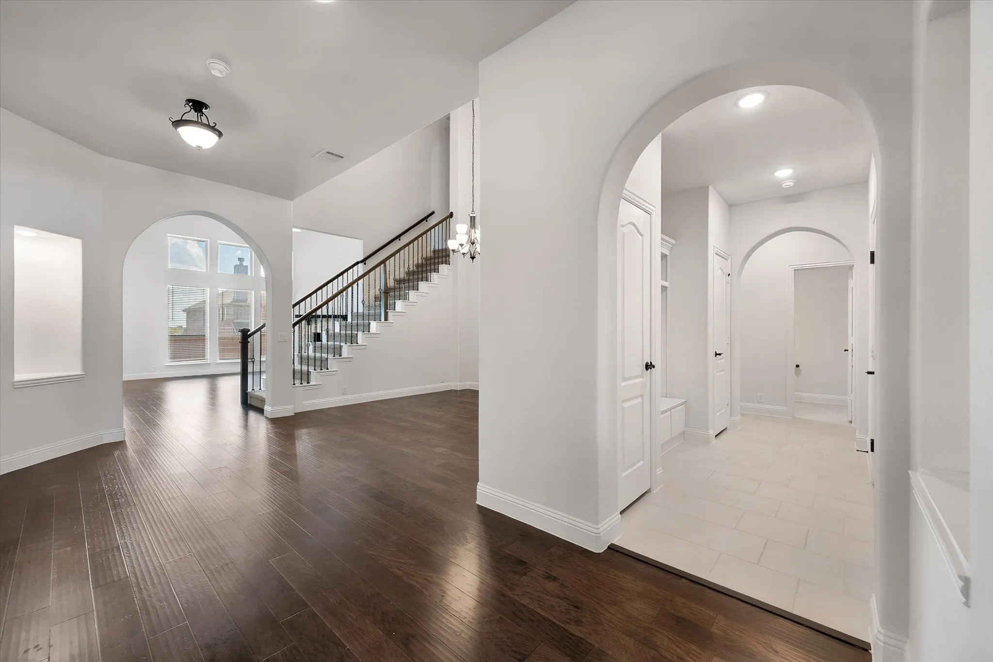 Here's a great shot of the staircase with its wrought-iron railings, and off to the right, you can see the hallway heading back toward the mudroom and garage entry.