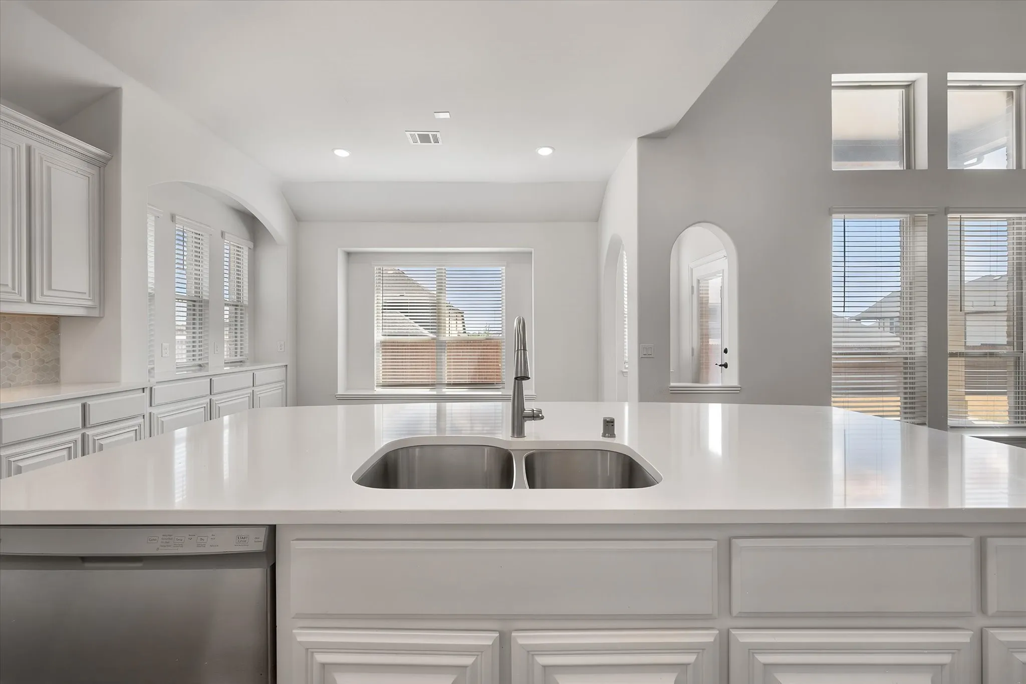 And here's the view from the sink — double basin, gorgeous quartz countertops, and windows right in front so you're never doing dishes without a view.