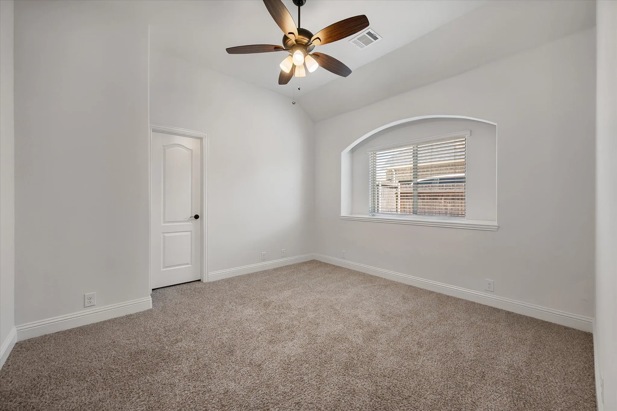 Soft carpet under your feet, a cozy arched window nook, and that vaulted ceiling makes it feel way bigger than a typical bedroom.