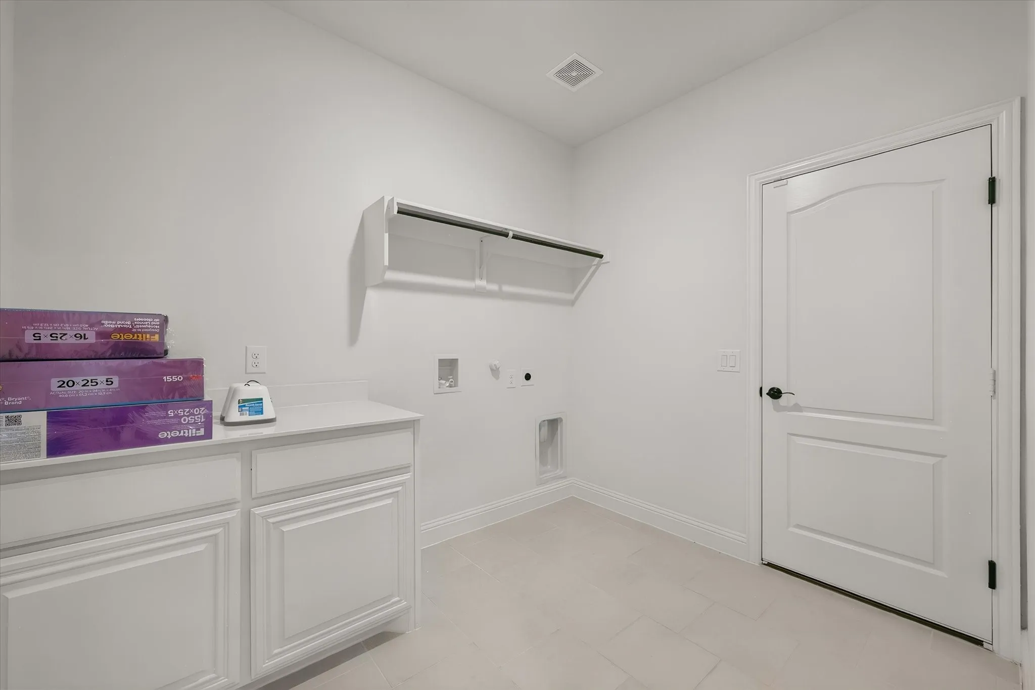 And right around the corner, your laundry room — plenty of counter space up top for folding, and cabinets for storage.
