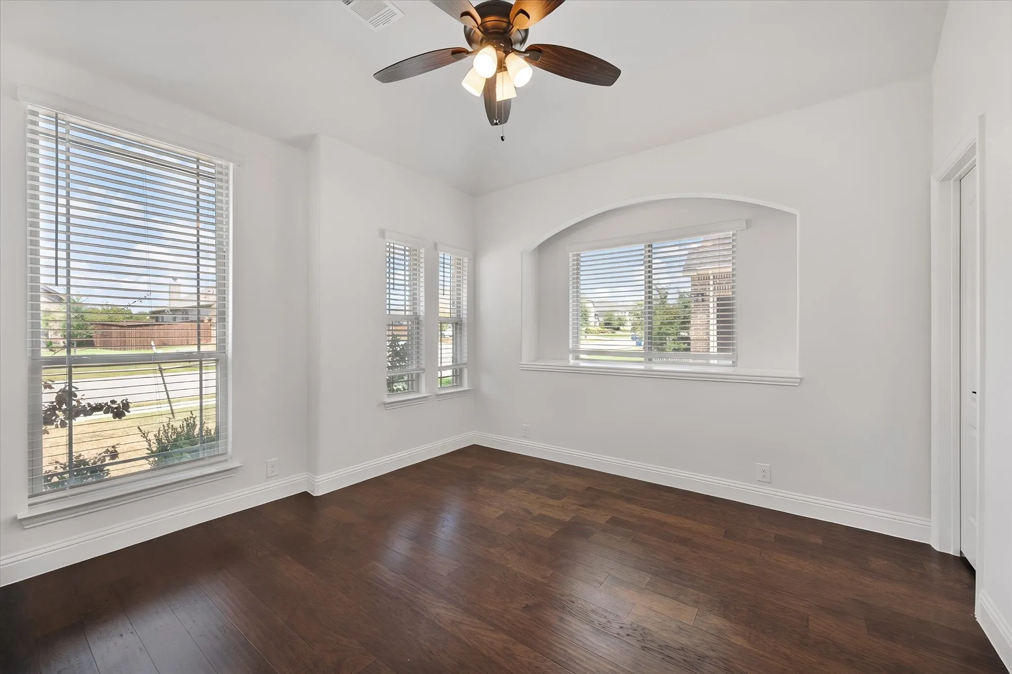 This front room is such a sweet spot — so many windows pouring in natural light, perfect for a home office, a den, whatever you need it to be.
