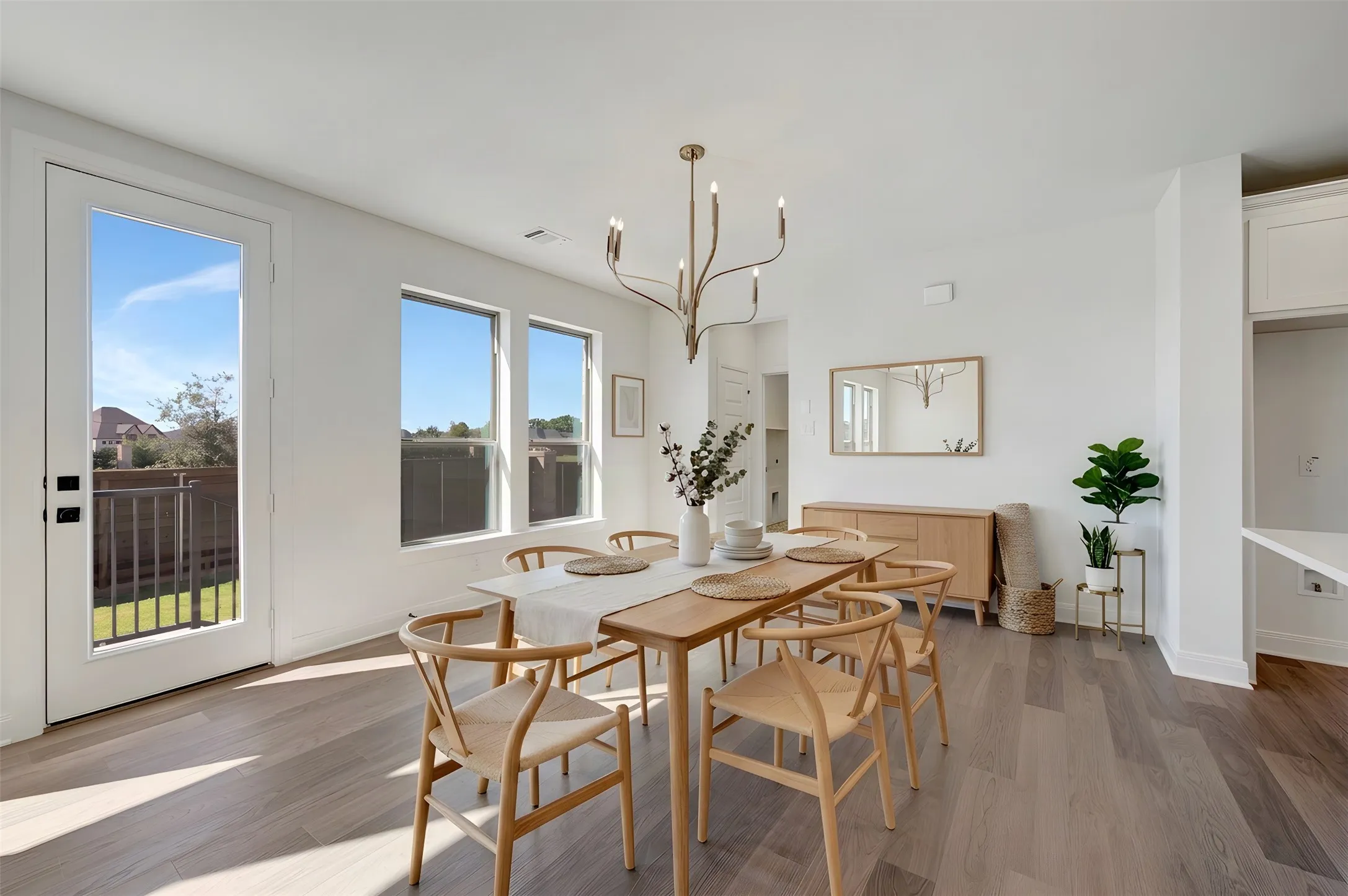 Wood-finish flooring, white walls, and a contemporary chandelier