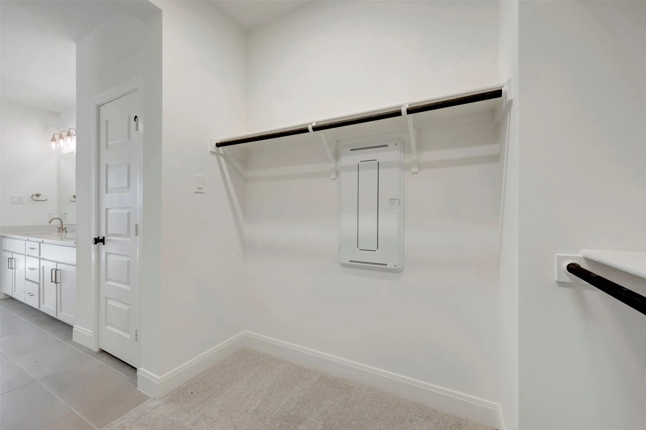 Built-in closet shelving and hanging rod with light-toned carpeting