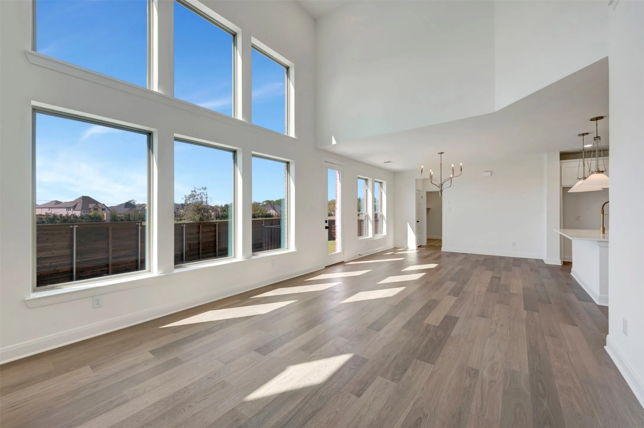 Vaulted ceilings above a spacious room with wood-finish flooring