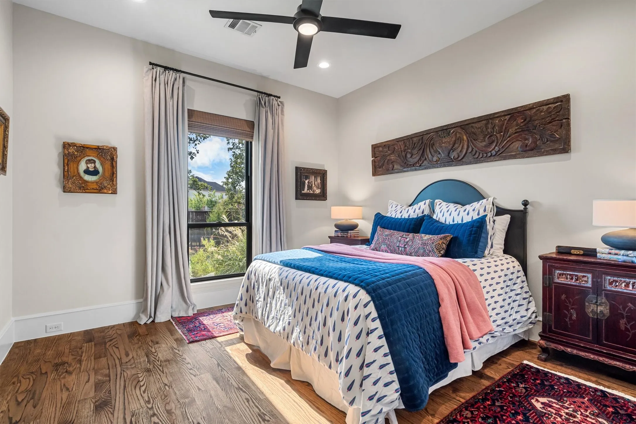 Comfortable secondary bedroom with wood-beamed ceiling and garden views.