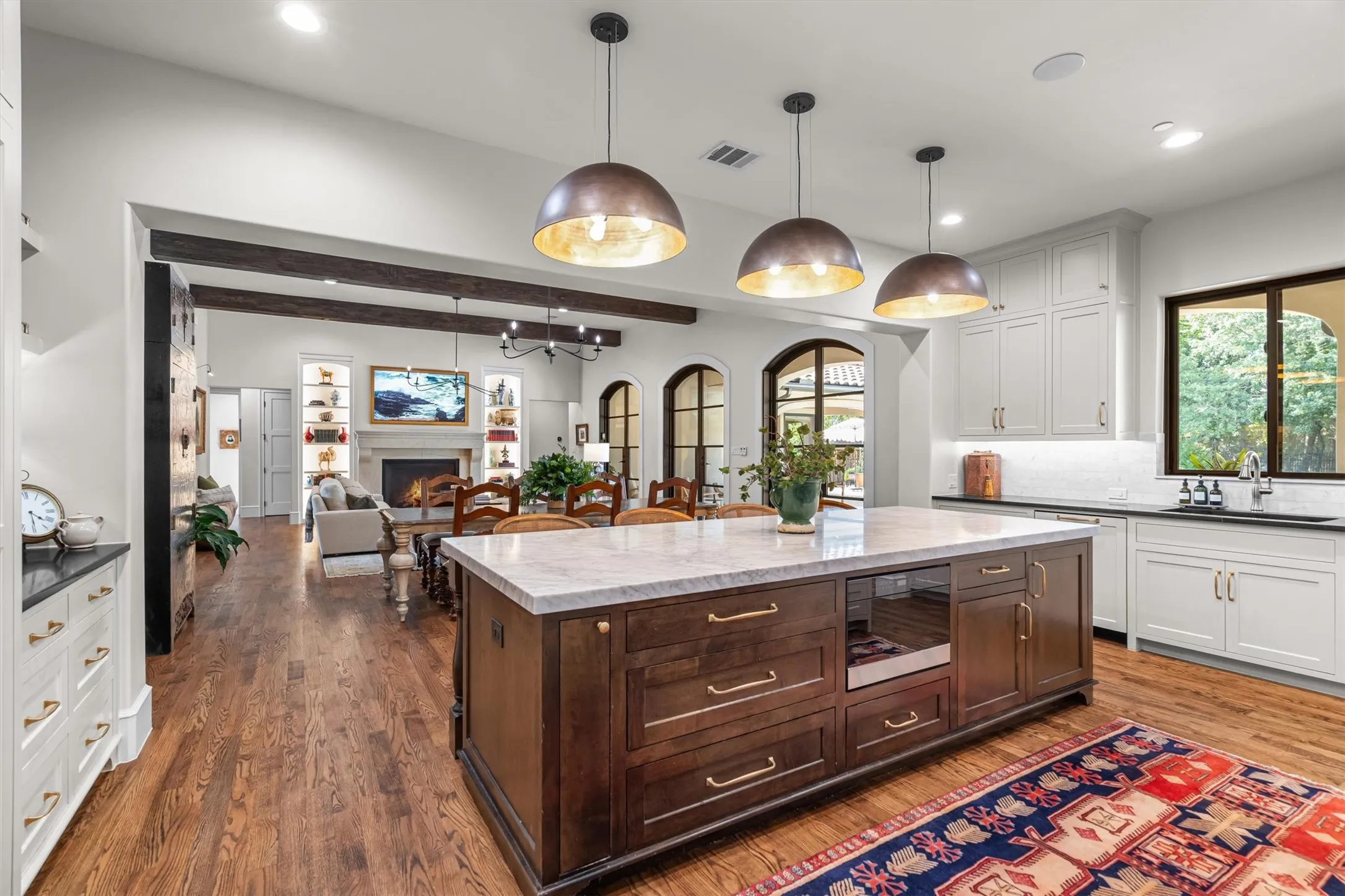 Expansive island kitchen opens to a casual dining nook, bathed in natural light.