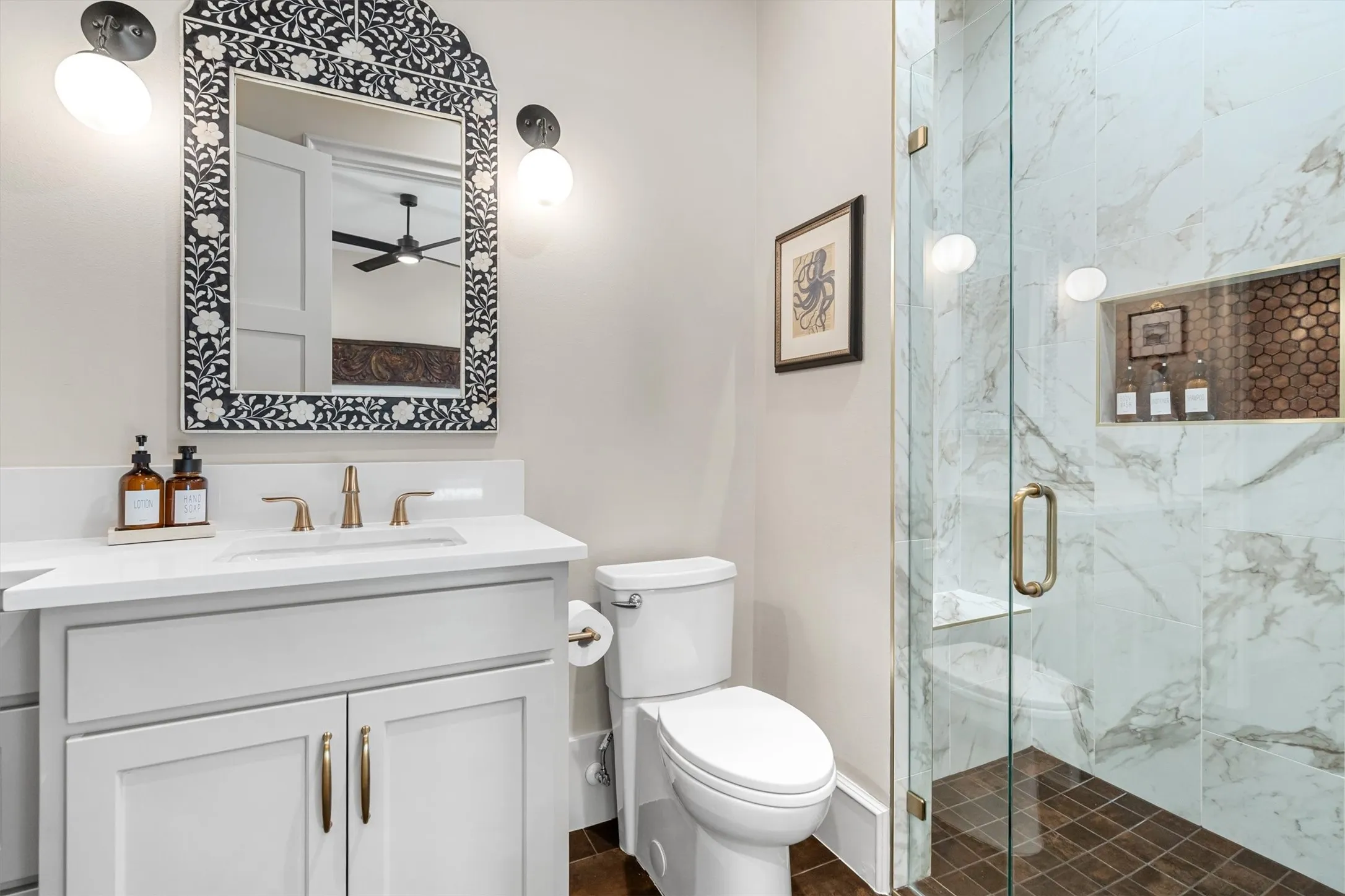 n-suite secondary bath with glass shower enclosure and marble-style tile.