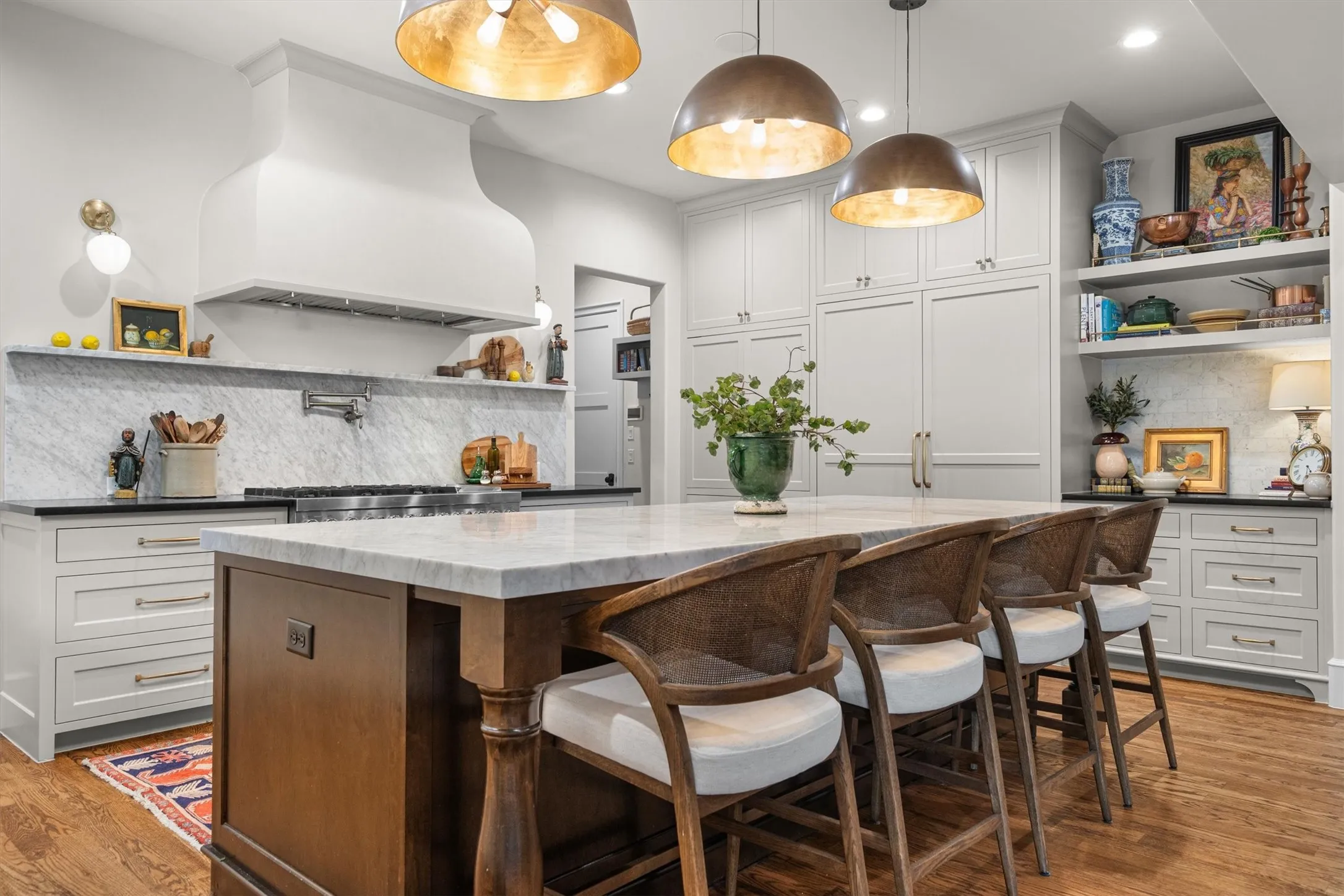 Custom cabinetry, quartz countertops, and rich wood island accents create a warm, gourmet feel.