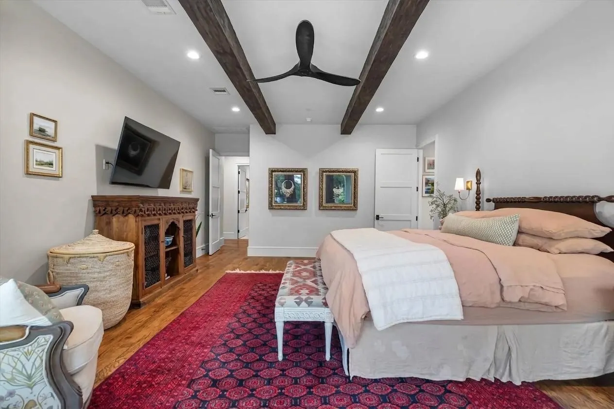 Warm and inviting primary suite with designer finishes, wood flooring, and abundant natural light.