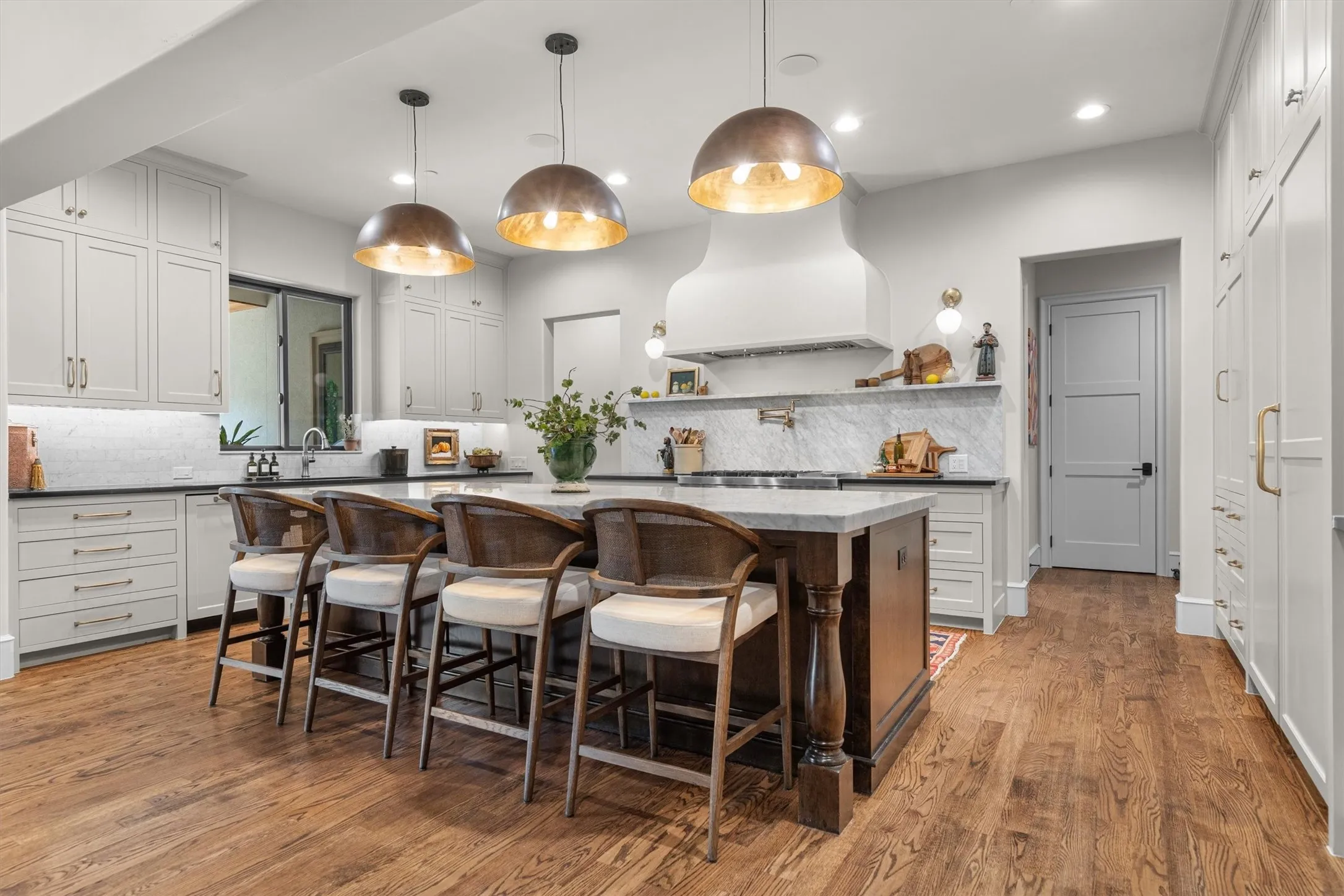 Chef's kitchen with oversized island, bar seating for six, and statement pendant lighting.