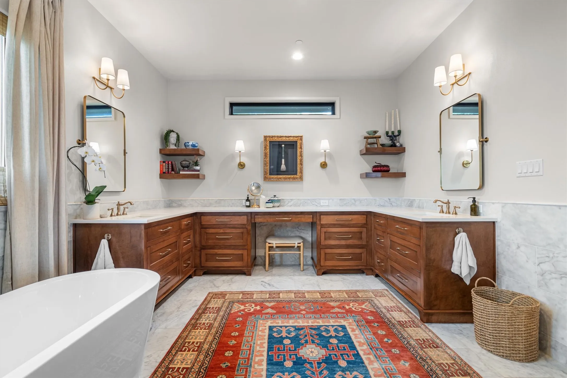 Dual vanity primary bath with custom wood cabinetry and elegant lighting.