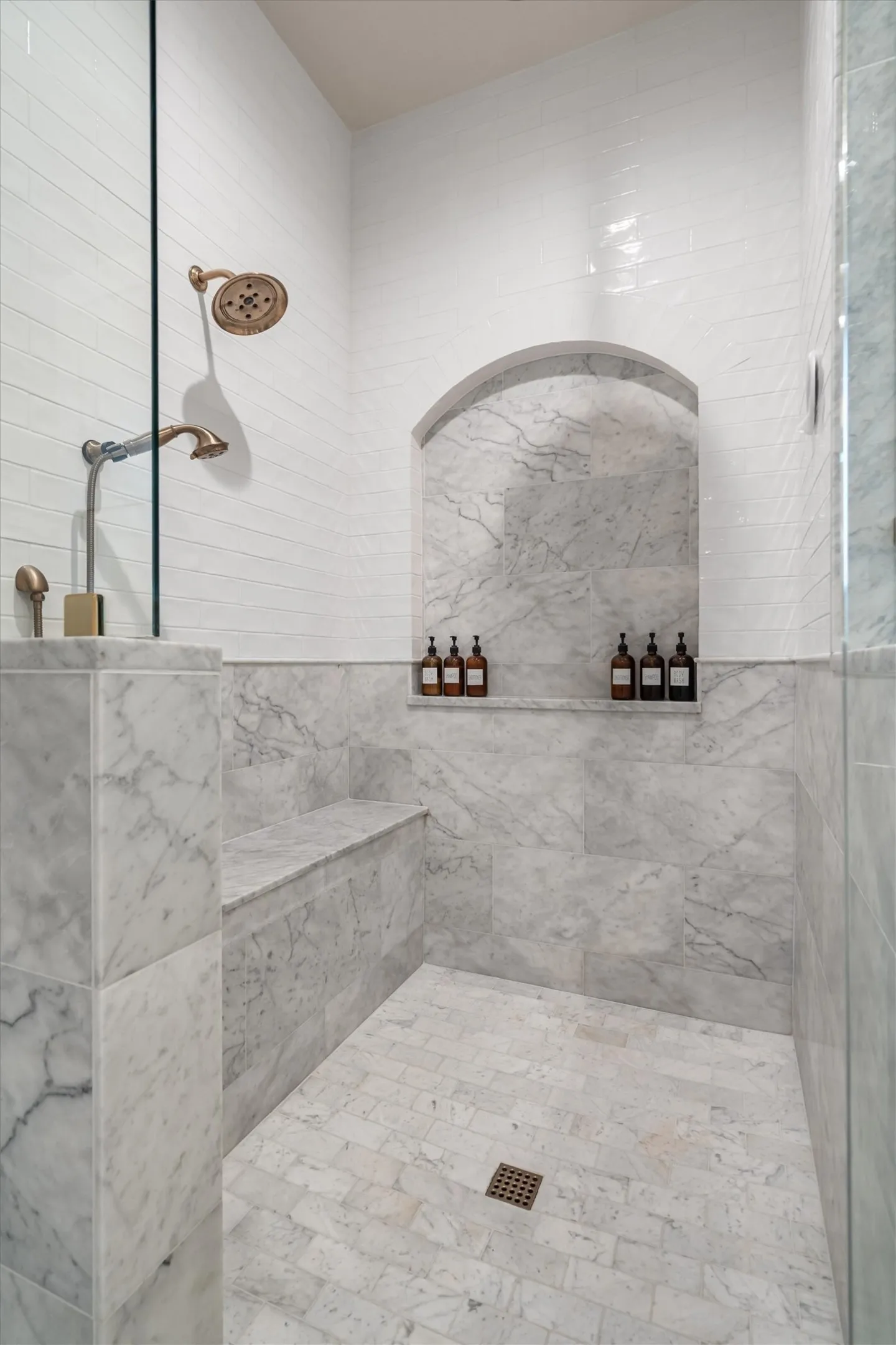 Oversized walk-in shower with dual shower heads and designer tile detail.