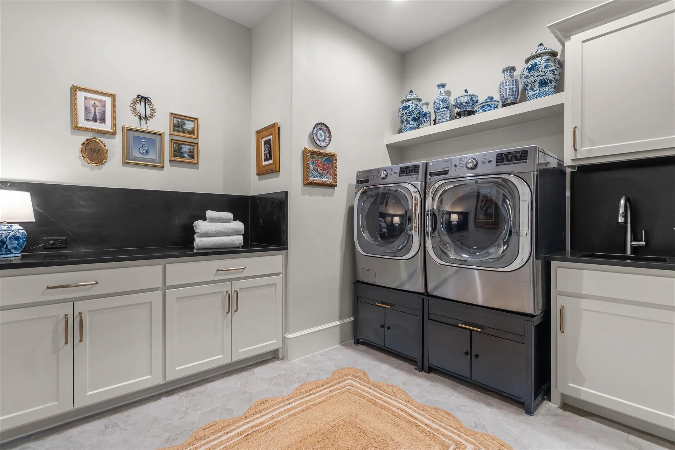 Oversized laundry room with abundant cabinetry and side-by-side washer/dryer setup.