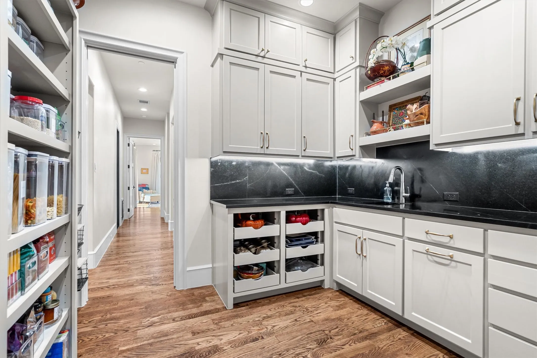 Walk-through butler's pantry with additional storage, prep space, and beverage cooler.