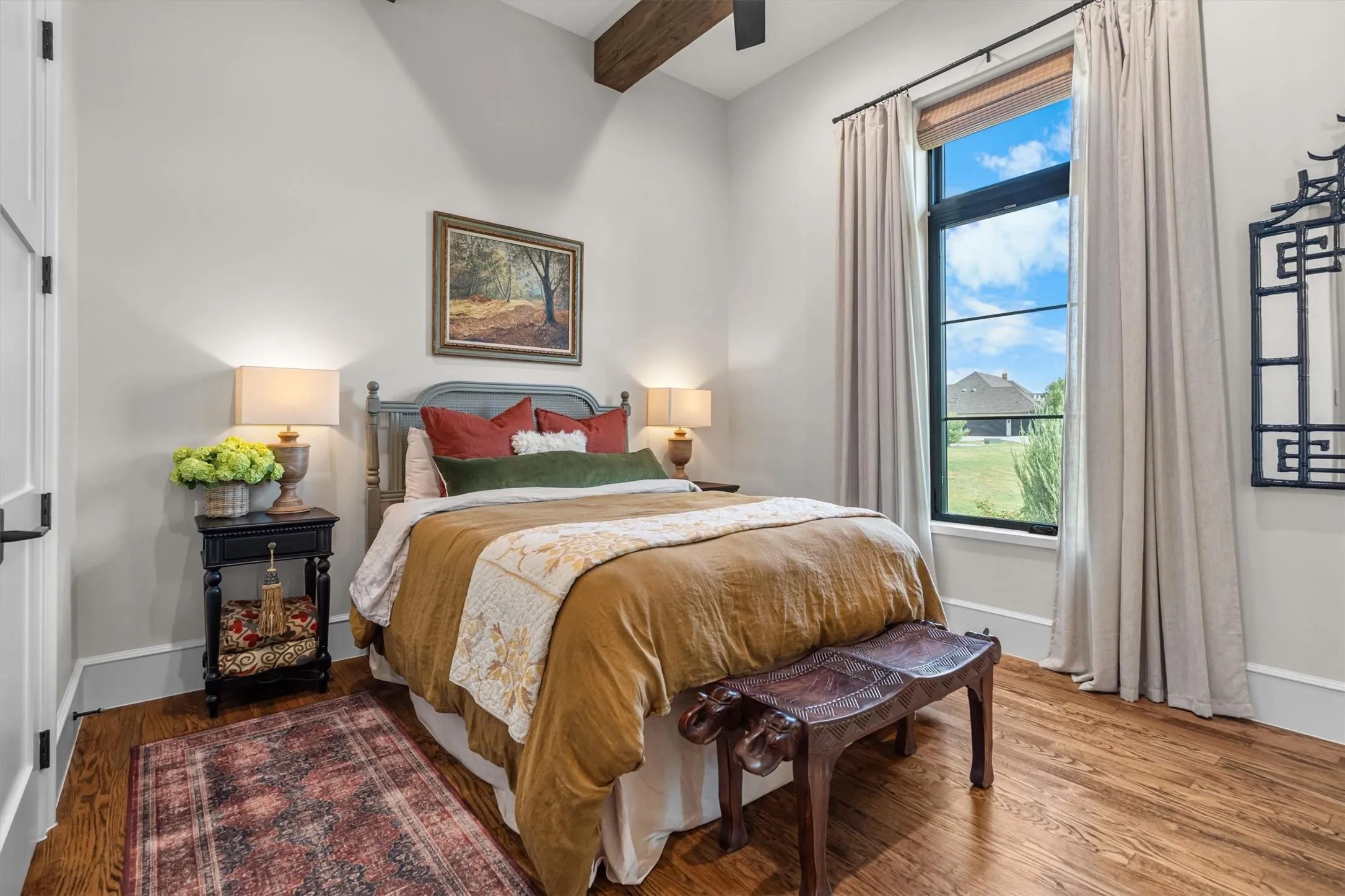 Bright secondary bedroom with hardwood floors and generous window light.
