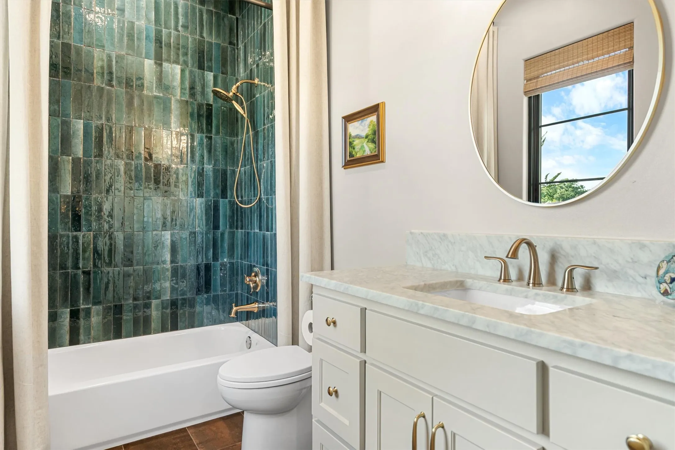Secondary bath with tub/shower combo and eye-catching teal tile accent.