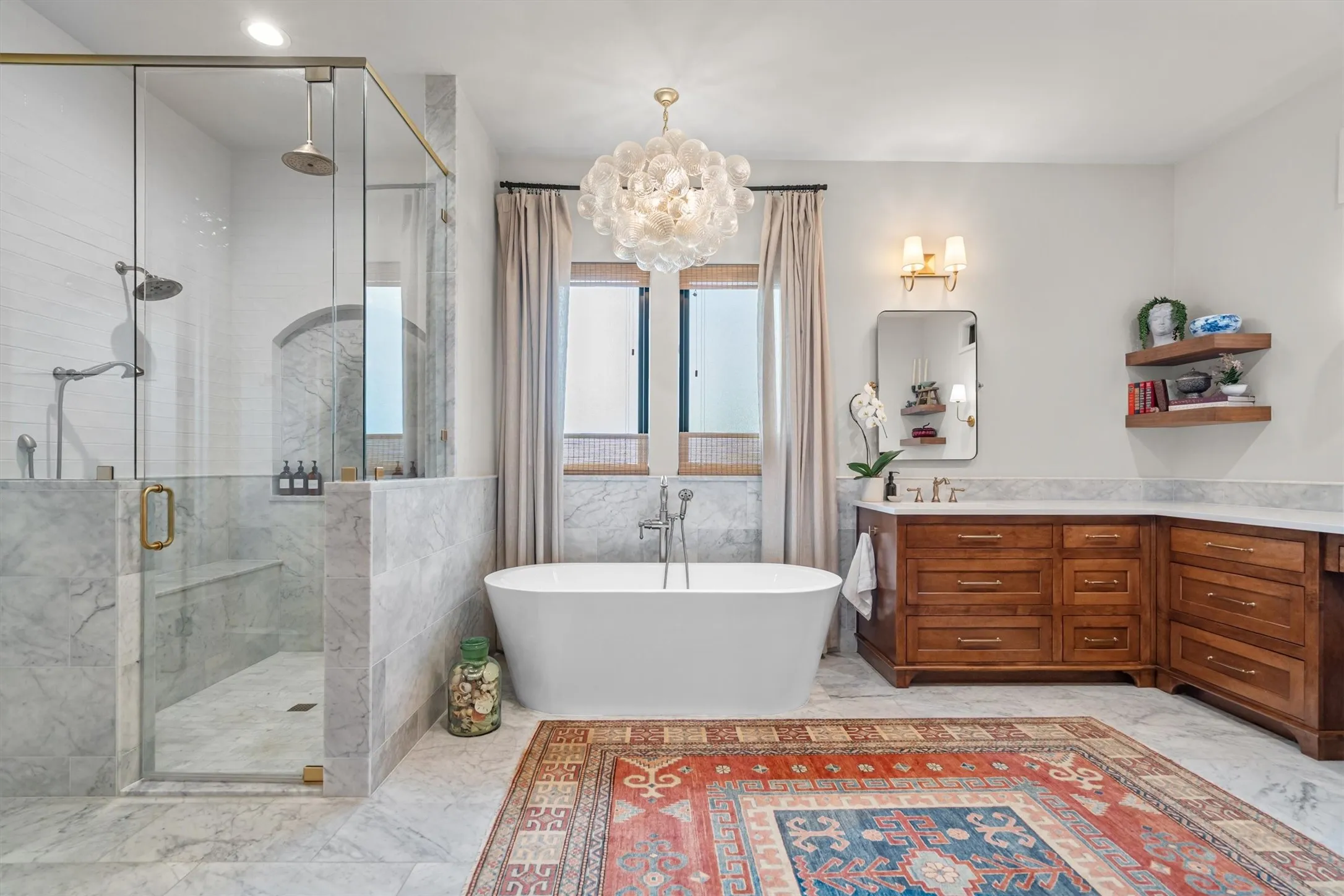 Spa-inspired primary bath with freestanding soaking tub and glass-enclosed shower.