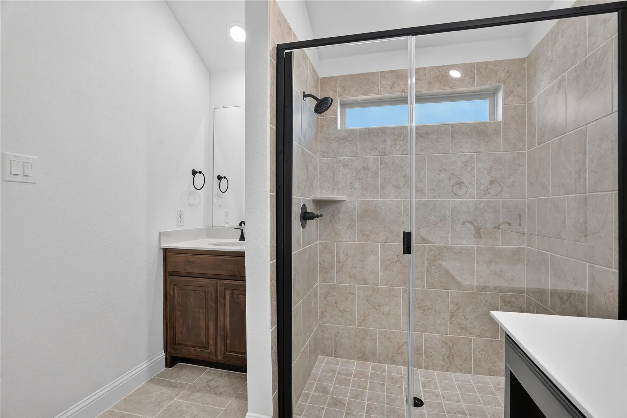 Walk-in shower with tile surround and glass enclosure