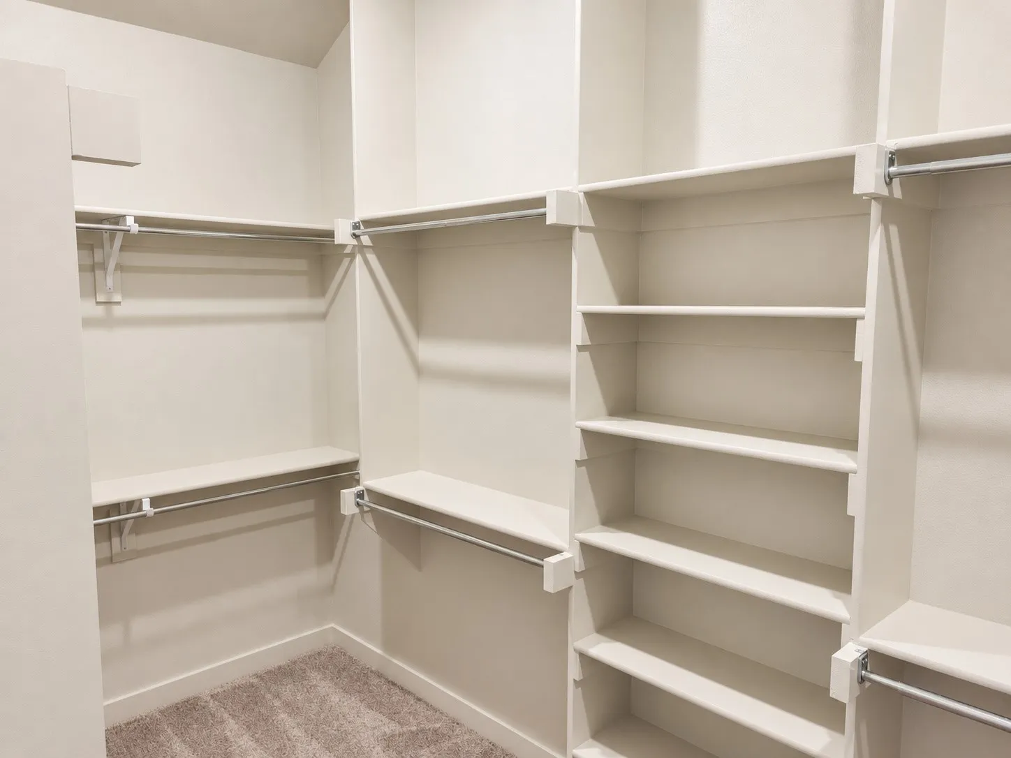 Custom built-in shelving, multiple hanging rods, and carpeted flooring
