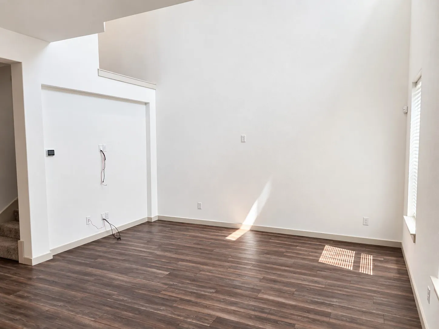 Soaring ceilings, wood-finish flooring, and white walls