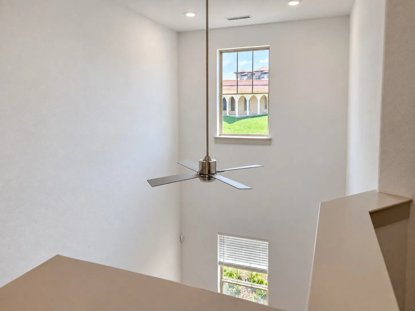 High ceilings with recessed lighting, modern ceiling fan, and multiple windows providing natural illumination
