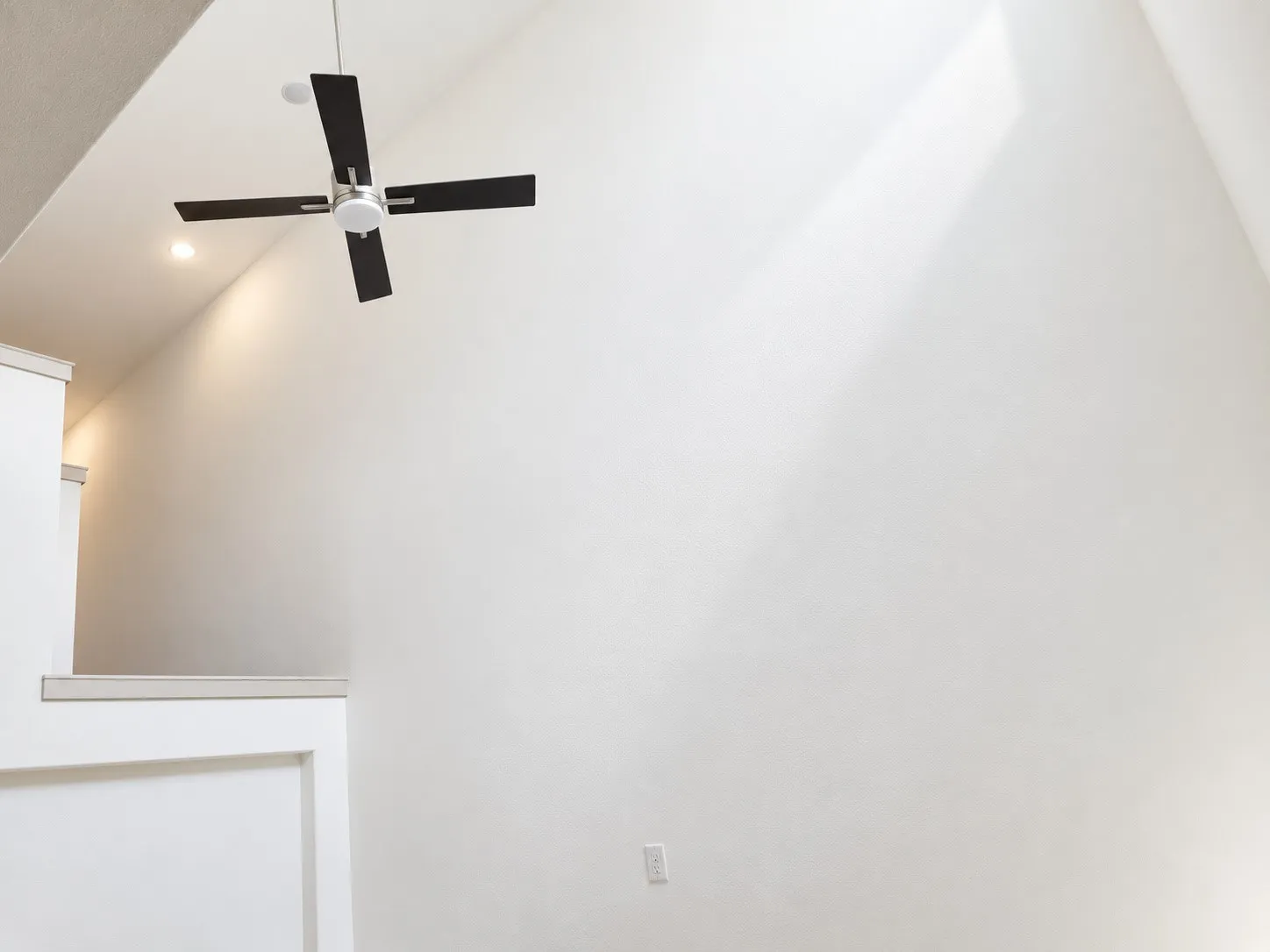 Vaulted ceiling with a contemporary ceiling fan, recessed lighting, and an open architectural element