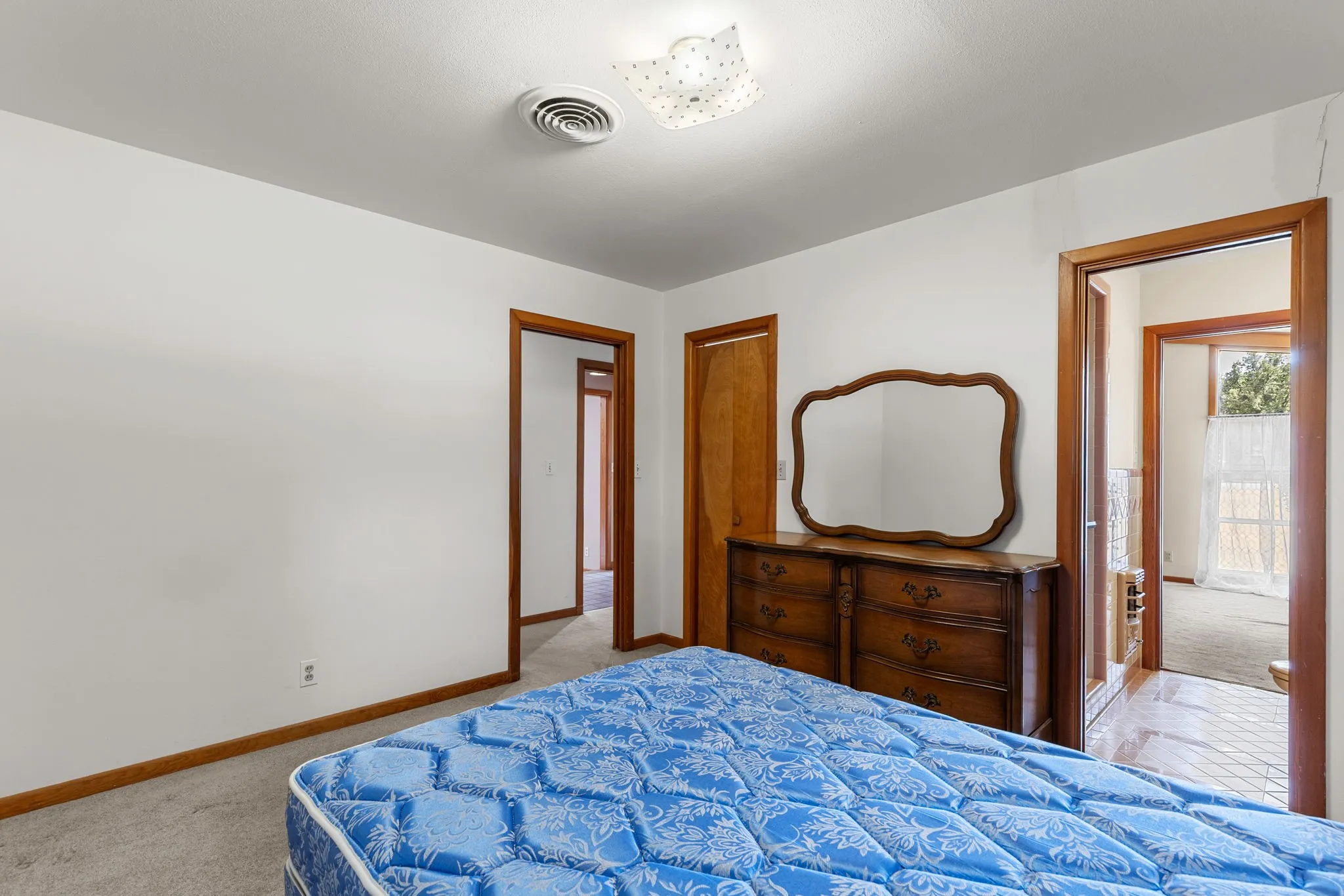 Recessed ceiling light, wall-to-wall carpeting, wood-finish trim, and white painted walls