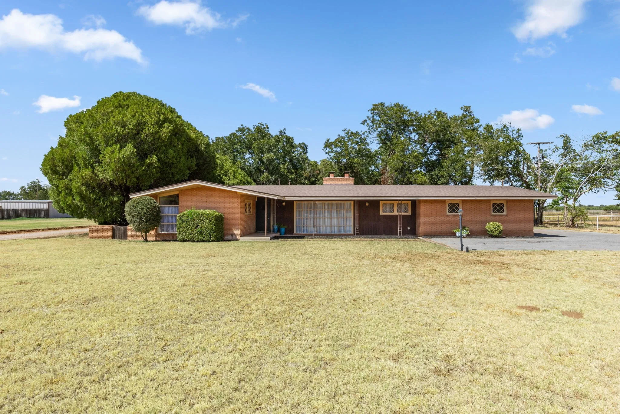 Brick exterior with a brown roof and a gravel driveway