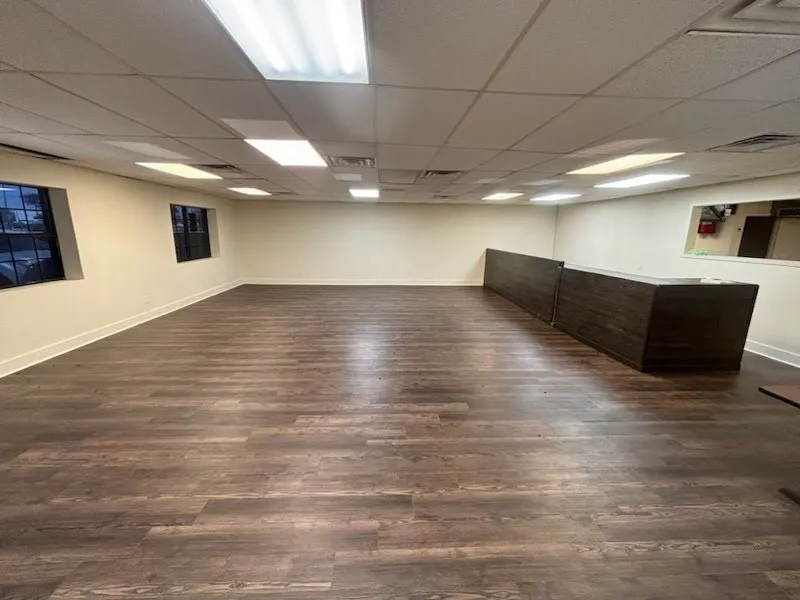 Spacious room with wood-finish flooring, recessed lighting, and a built-in wood-finish counter