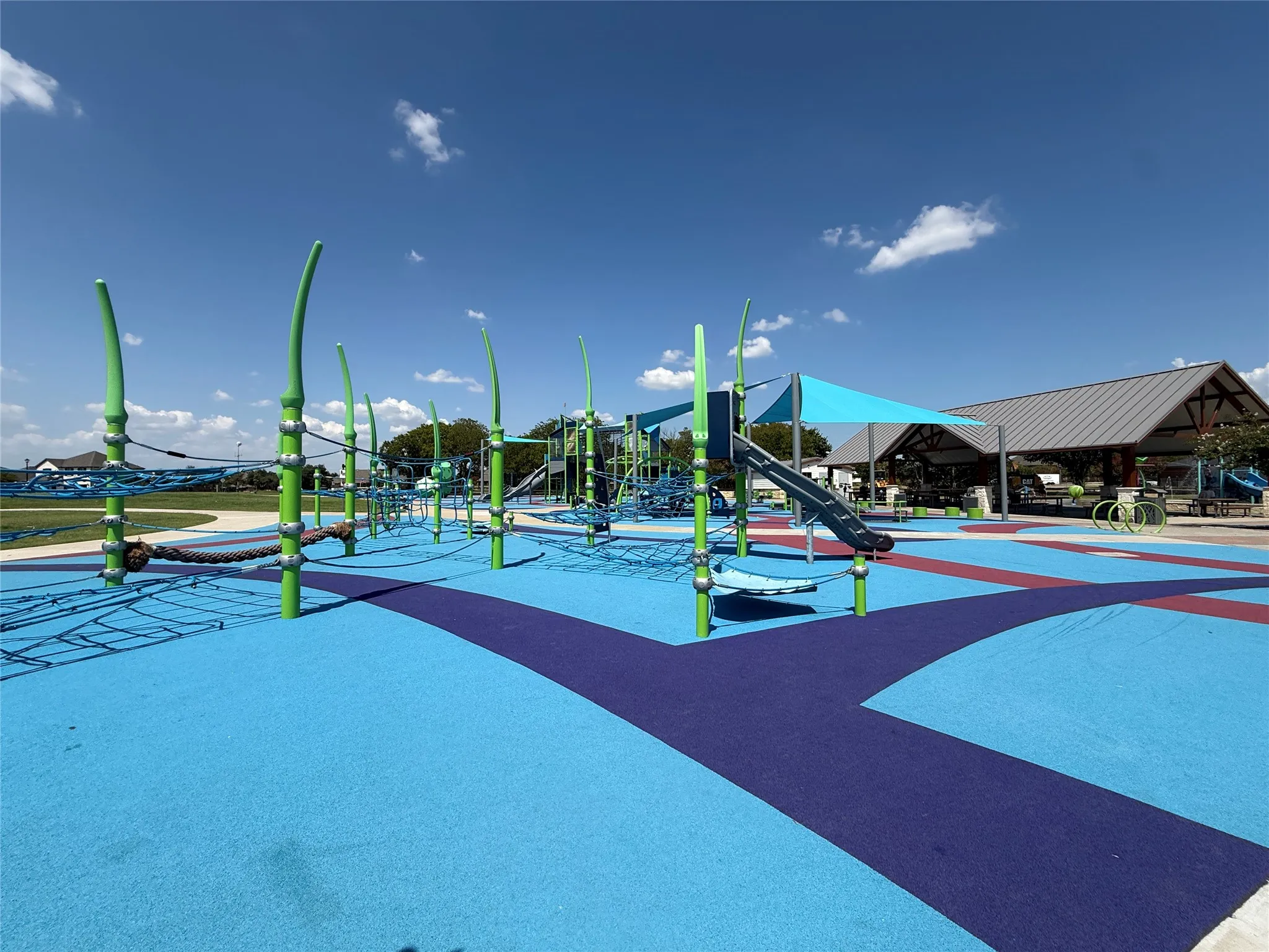 Sachse City Park with a modern playground covered with a rubber surface, covered picnic area, and a splash pad just around the corner.