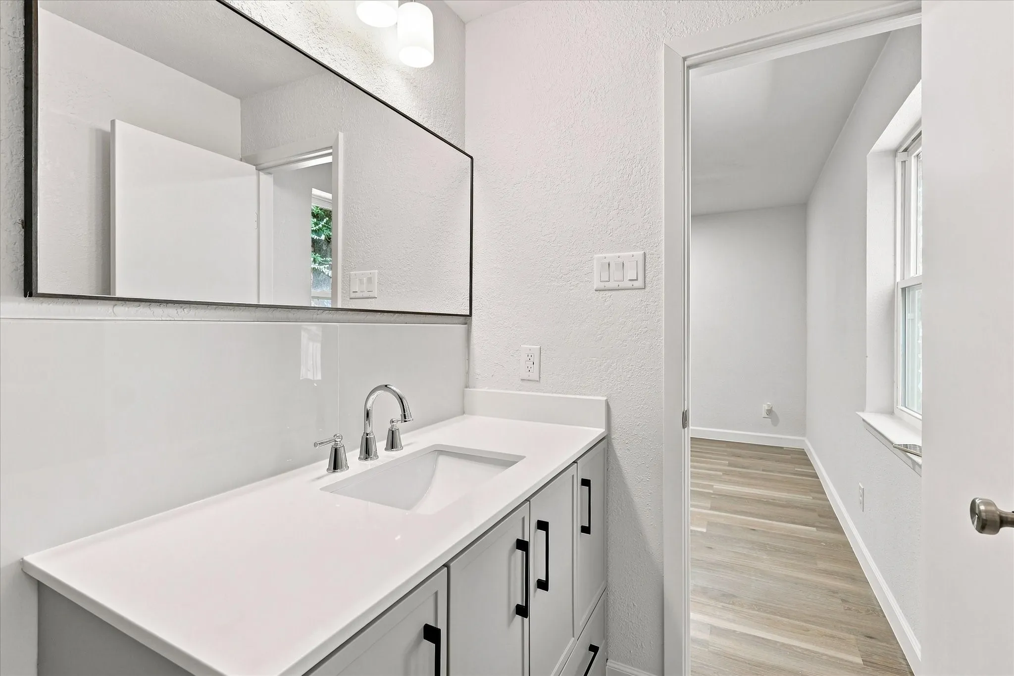 Vanity with integrated sink, polished chrome faucet, and quartz countertop
