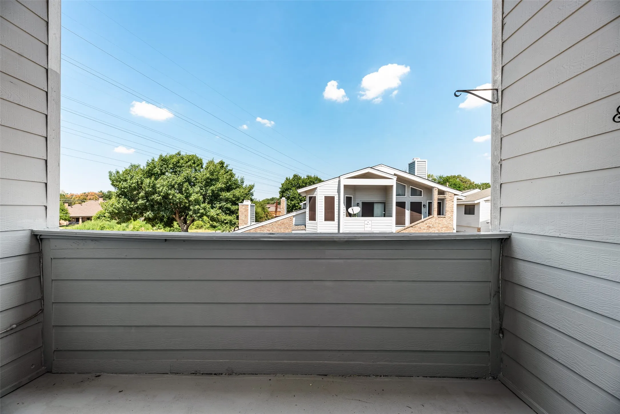 Outdoor balcony featuring horizontal siding and concrete flooring