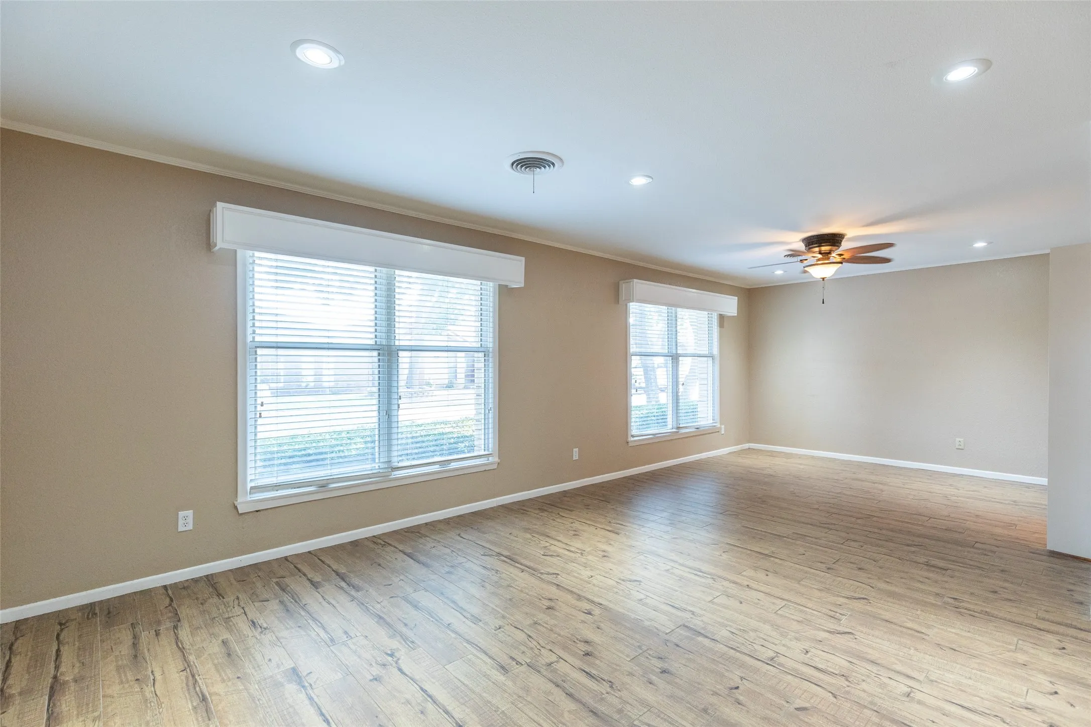 Recessed lighting, ceiling fan, wood-finish flooring, and two windows